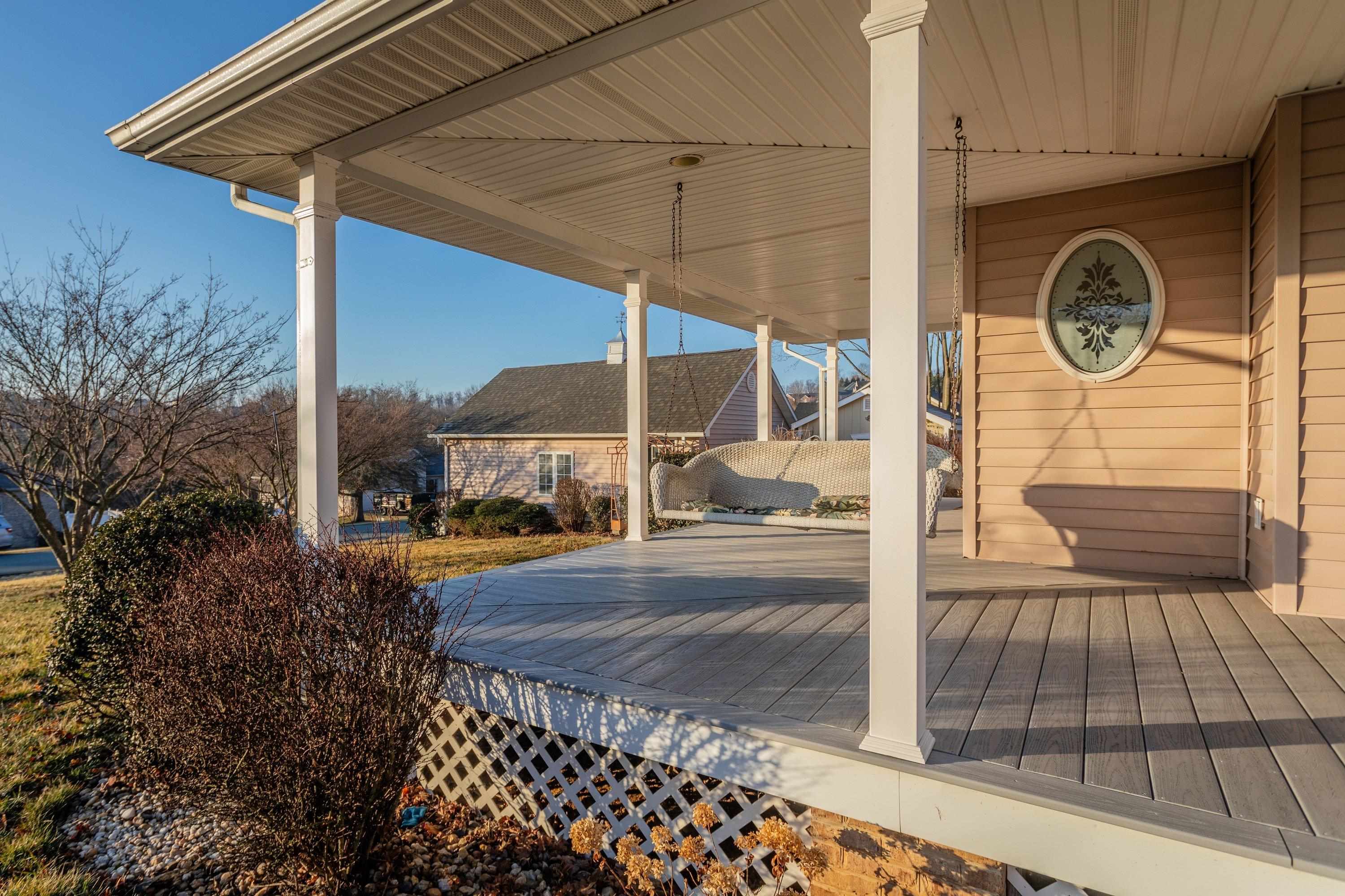 The front porch is very large and wraps around the front and sides of the home.  This porch offers composite deck flooring boards, and offers plenty of space for sitting and gathering with family and friends.