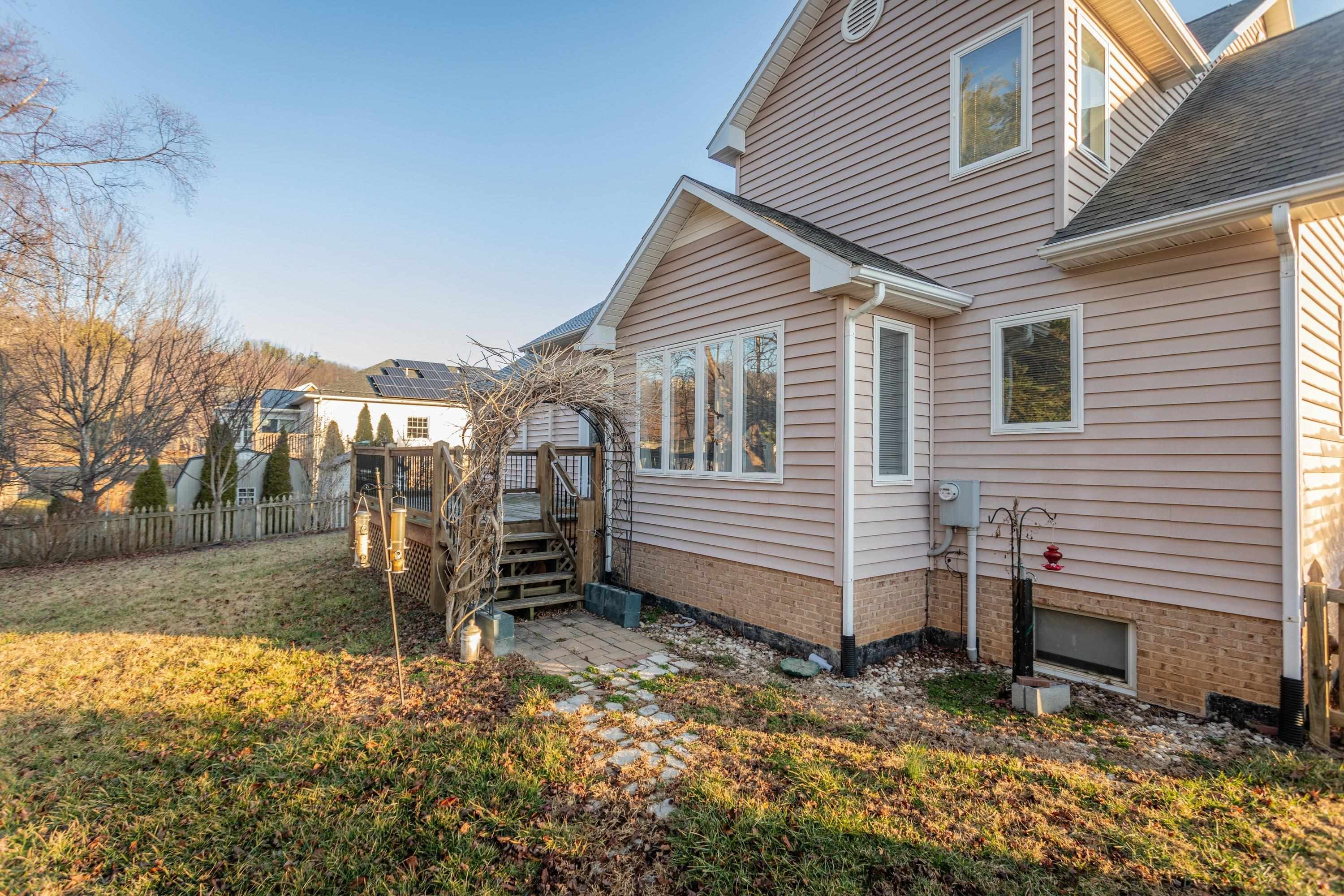 The rear of the home highlights the spacious wooden deck off the rear of the home.  These photos capture the large, level backyard area, landscaping, and storage building.