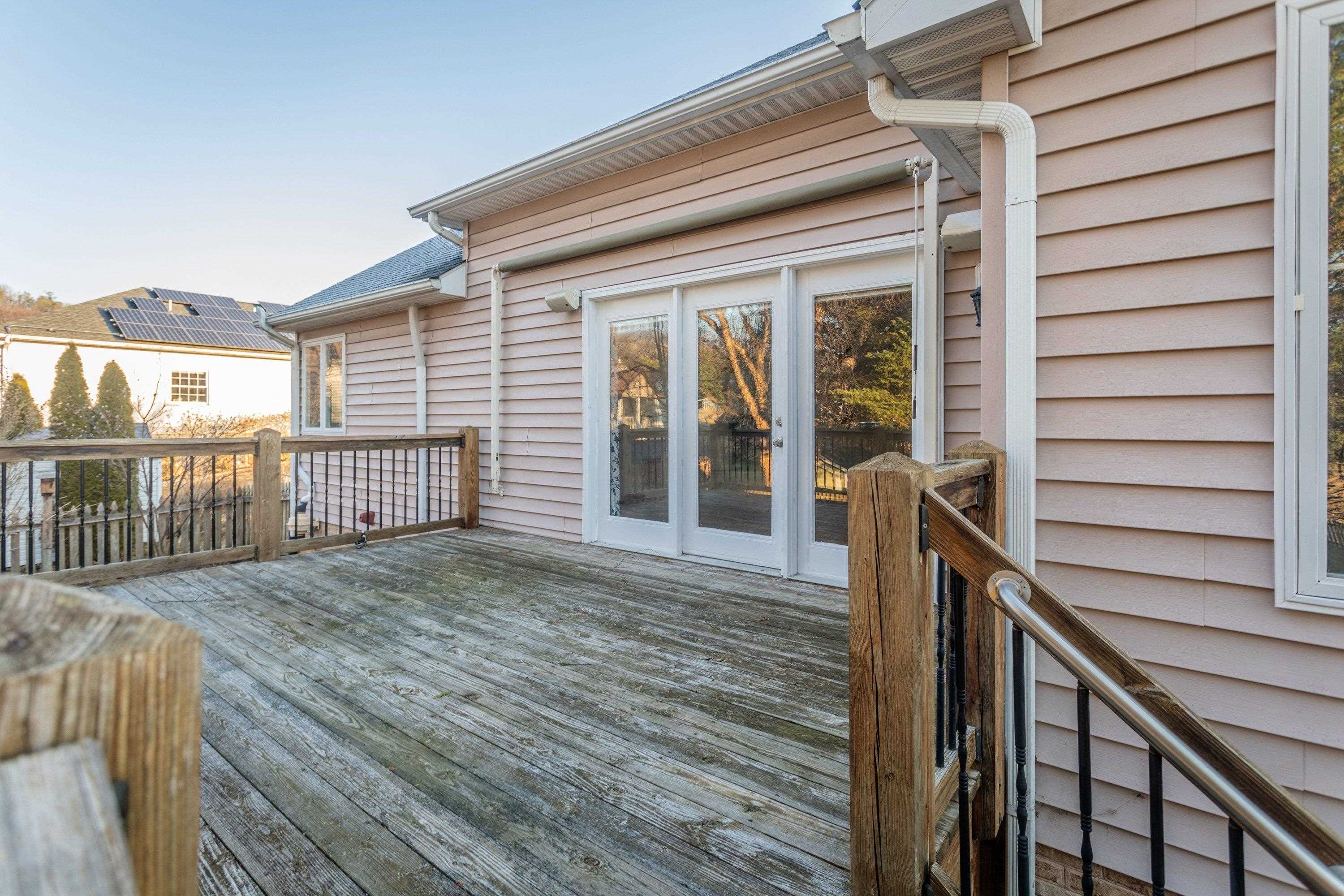 The rear of the home highlights the spacious wooden deck off the rear of the home.  These photos capture the large, level backyard area, landscaping, and storage building.