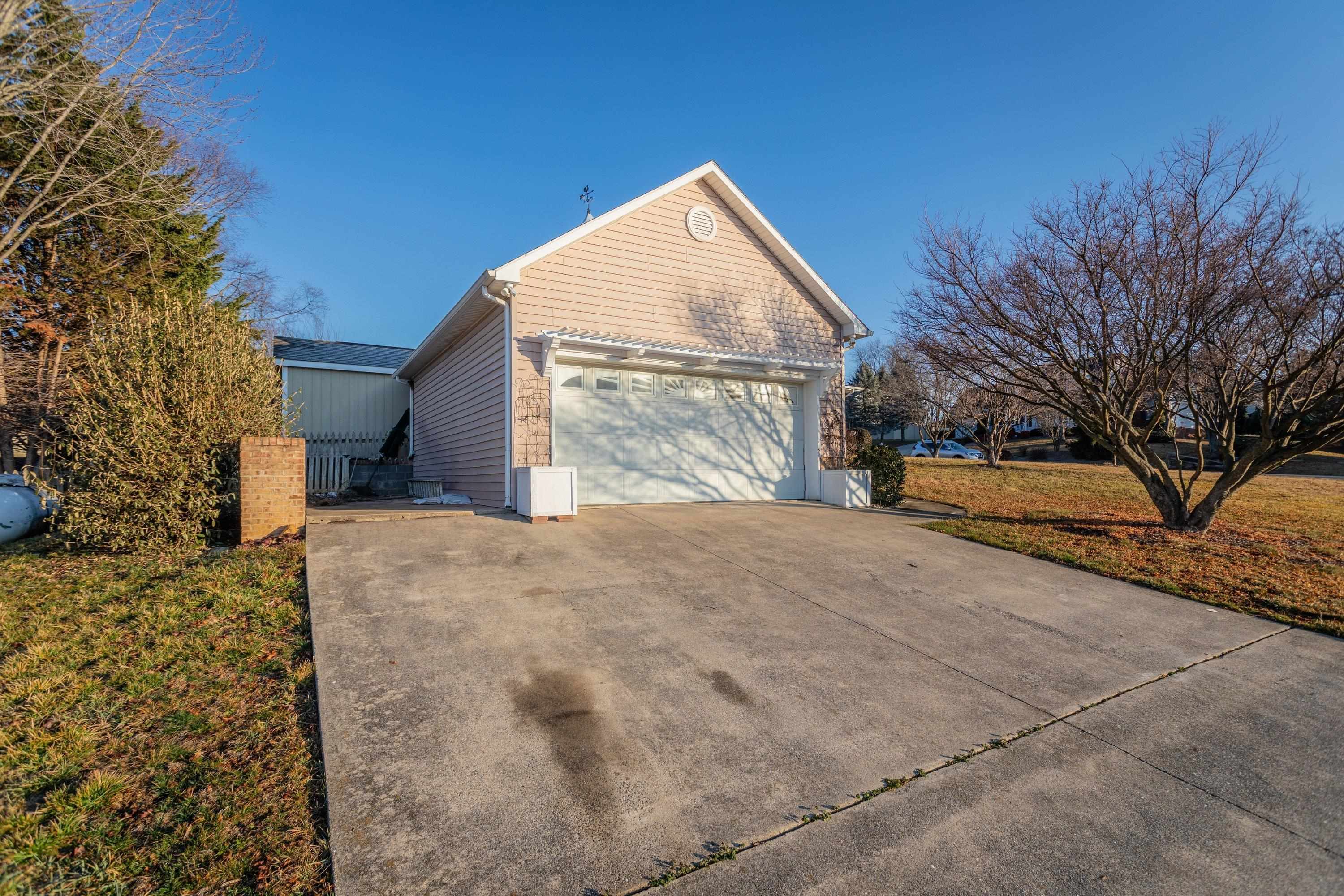 This home features a large concrete driveway leading to the spacious detached garage of the home.
