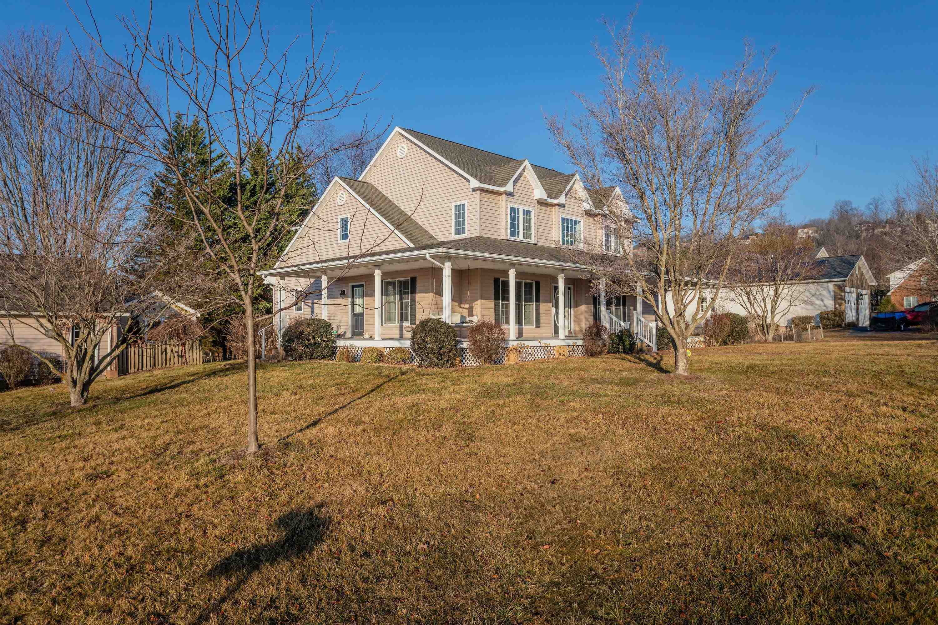 The front view of the home highlights the large wrap-around porch of the home, detached garage, large level yard of the home, and much more!