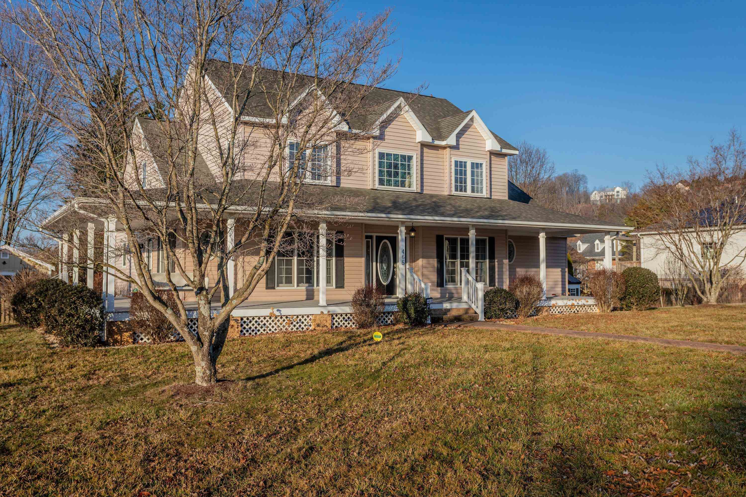 The front view of the home highlights the large wrap-around porch of the home, detached garage, large level yard of the home, and much more!