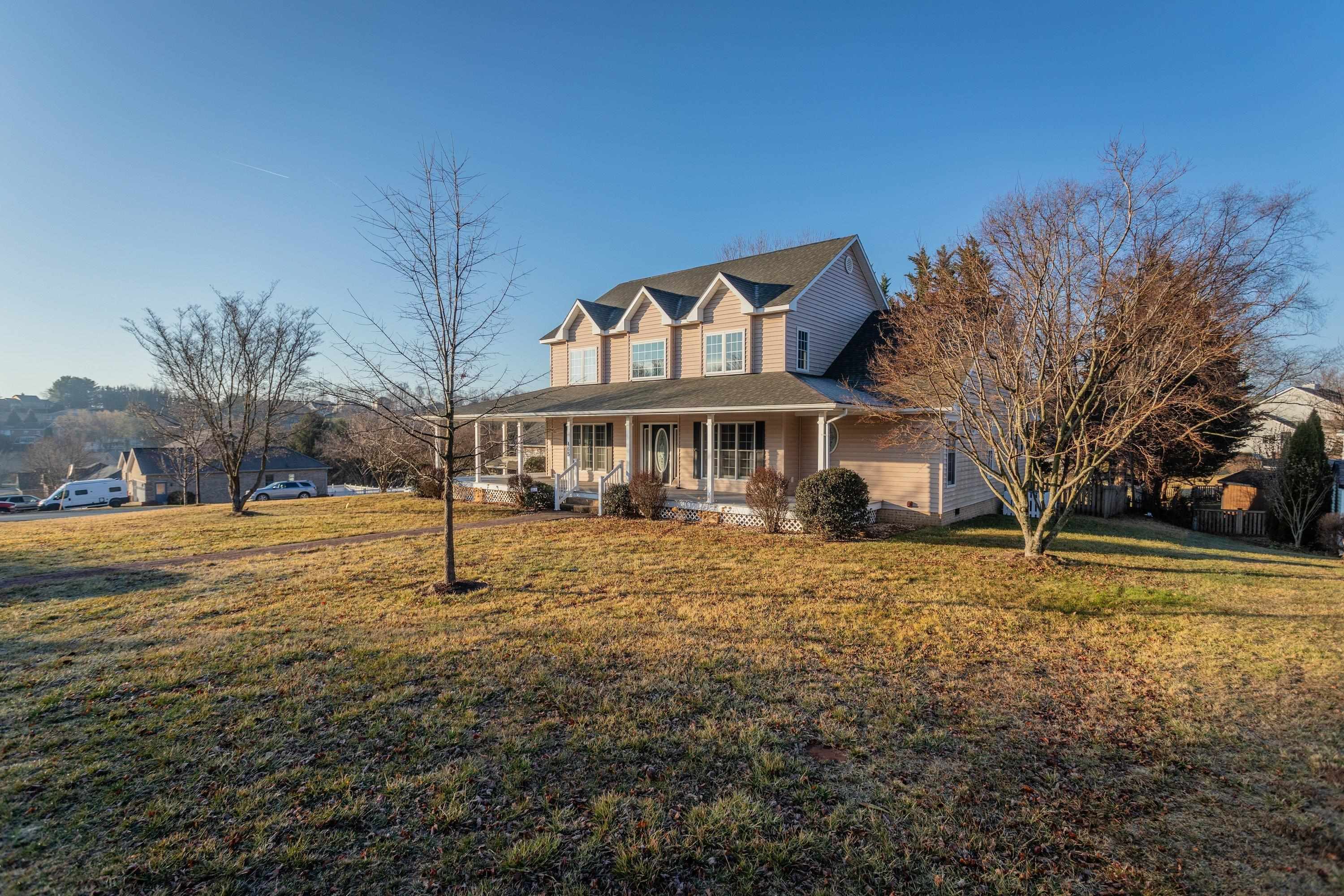 The front view of the home highlights the large wrap-around porch of the home, detached garage, large level yard of the home, and much more!