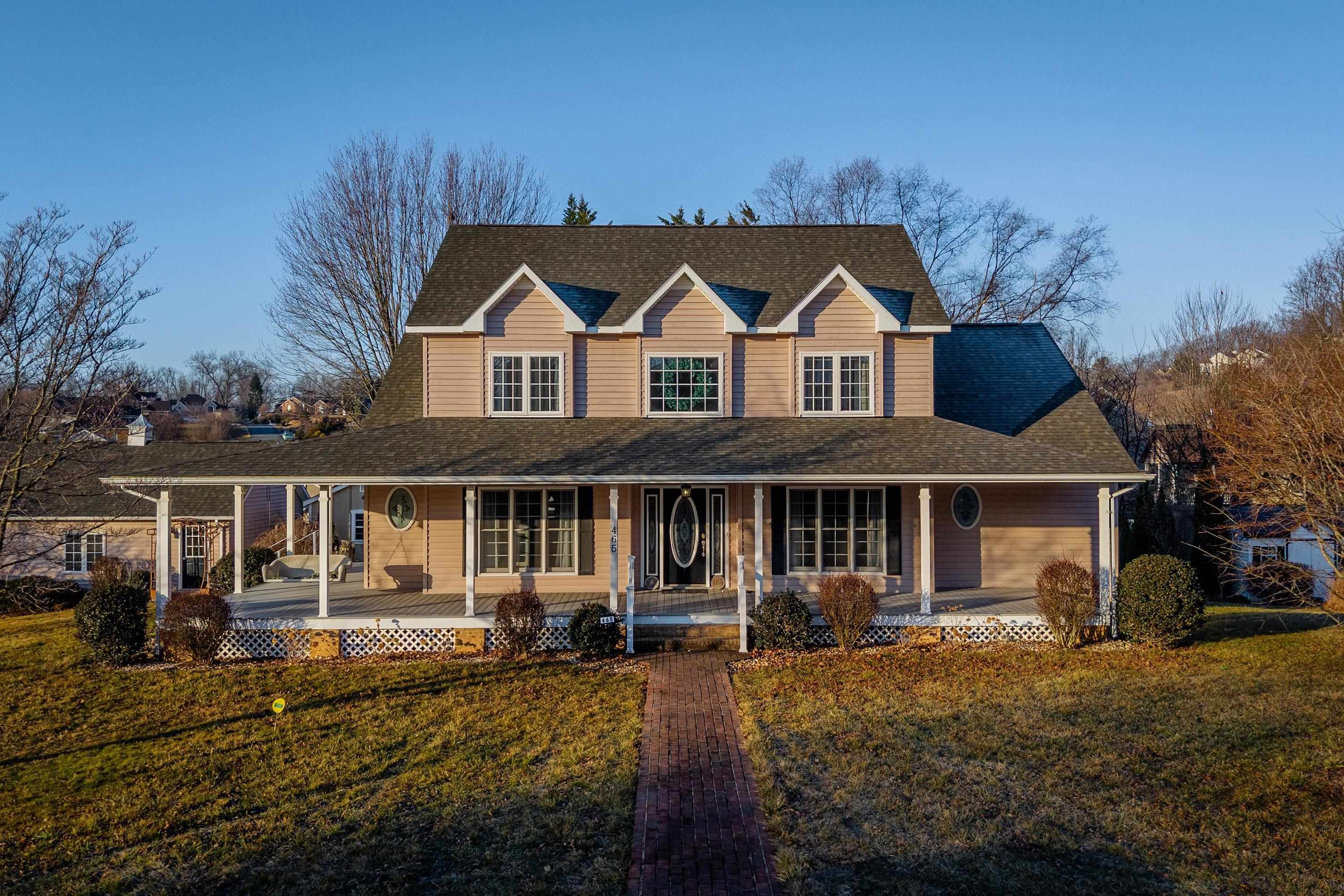 The front view of the home highlights the large wrap-around porch of the home, detached garage, large level yard of the home, and much more!