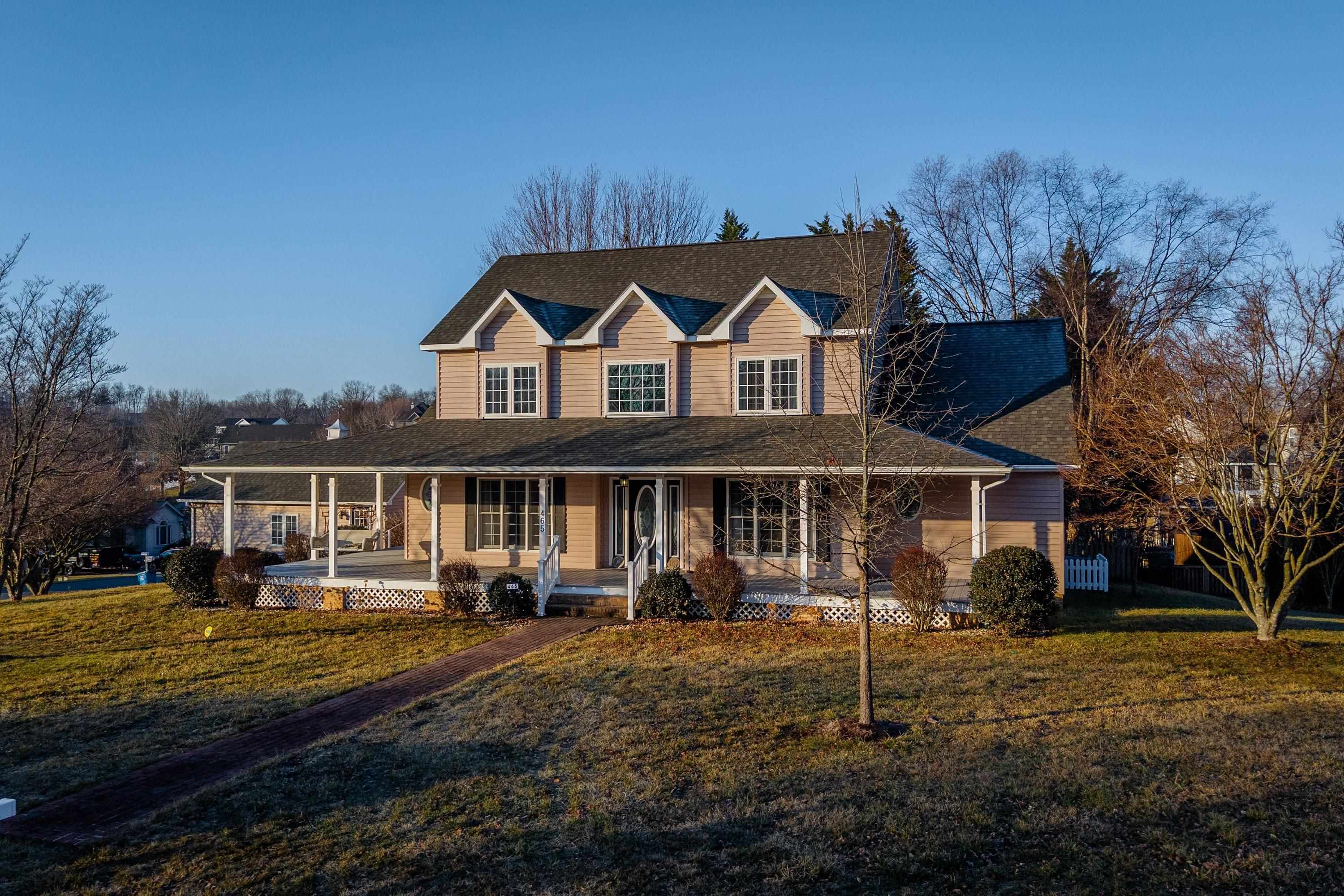 The front view of the home highlights the large wrap-around porch of the home, detached garage, large level yard of the home, and much more!