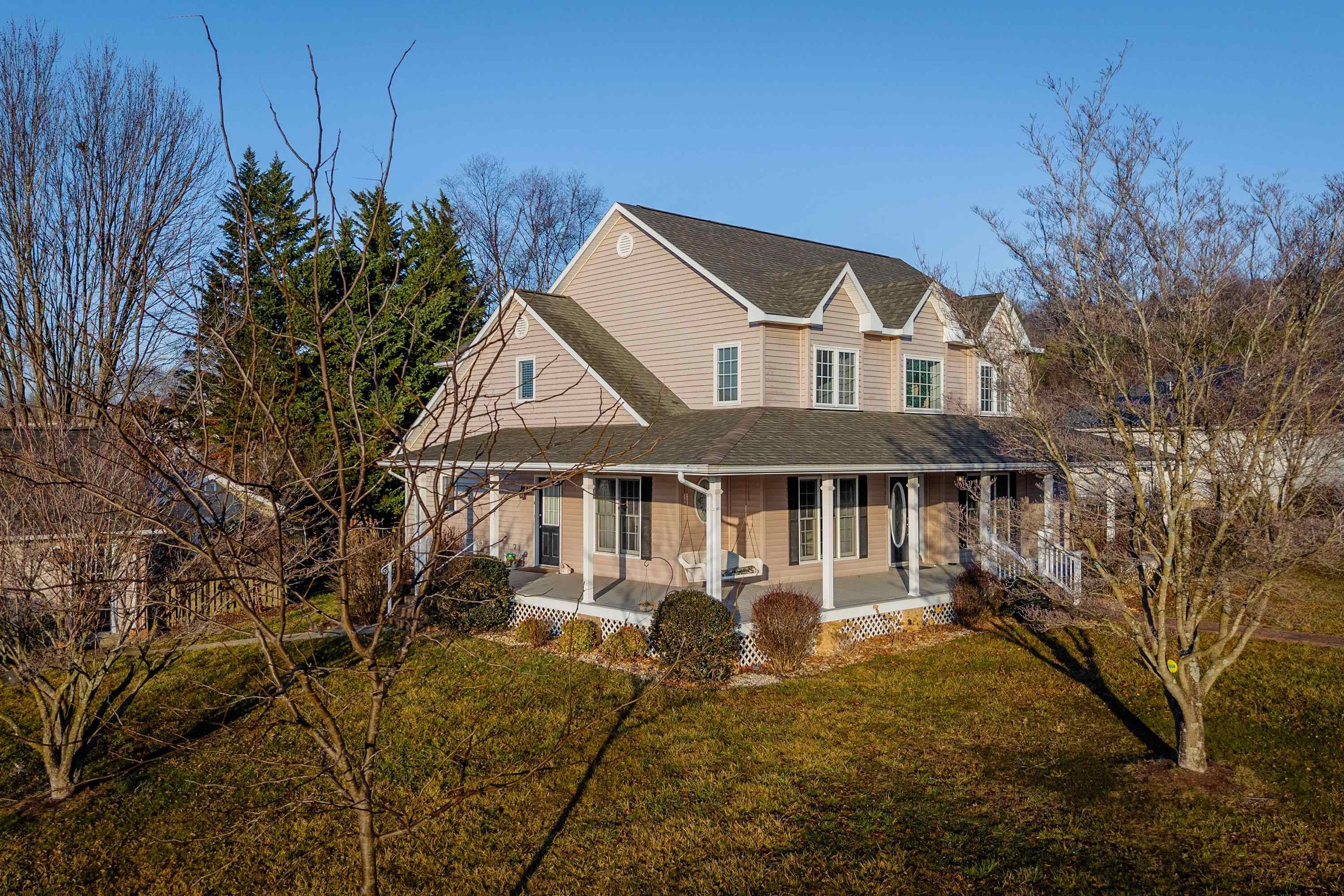 The side view highlights the level lot space, mature trees and landscaping, and large driveway for parking.