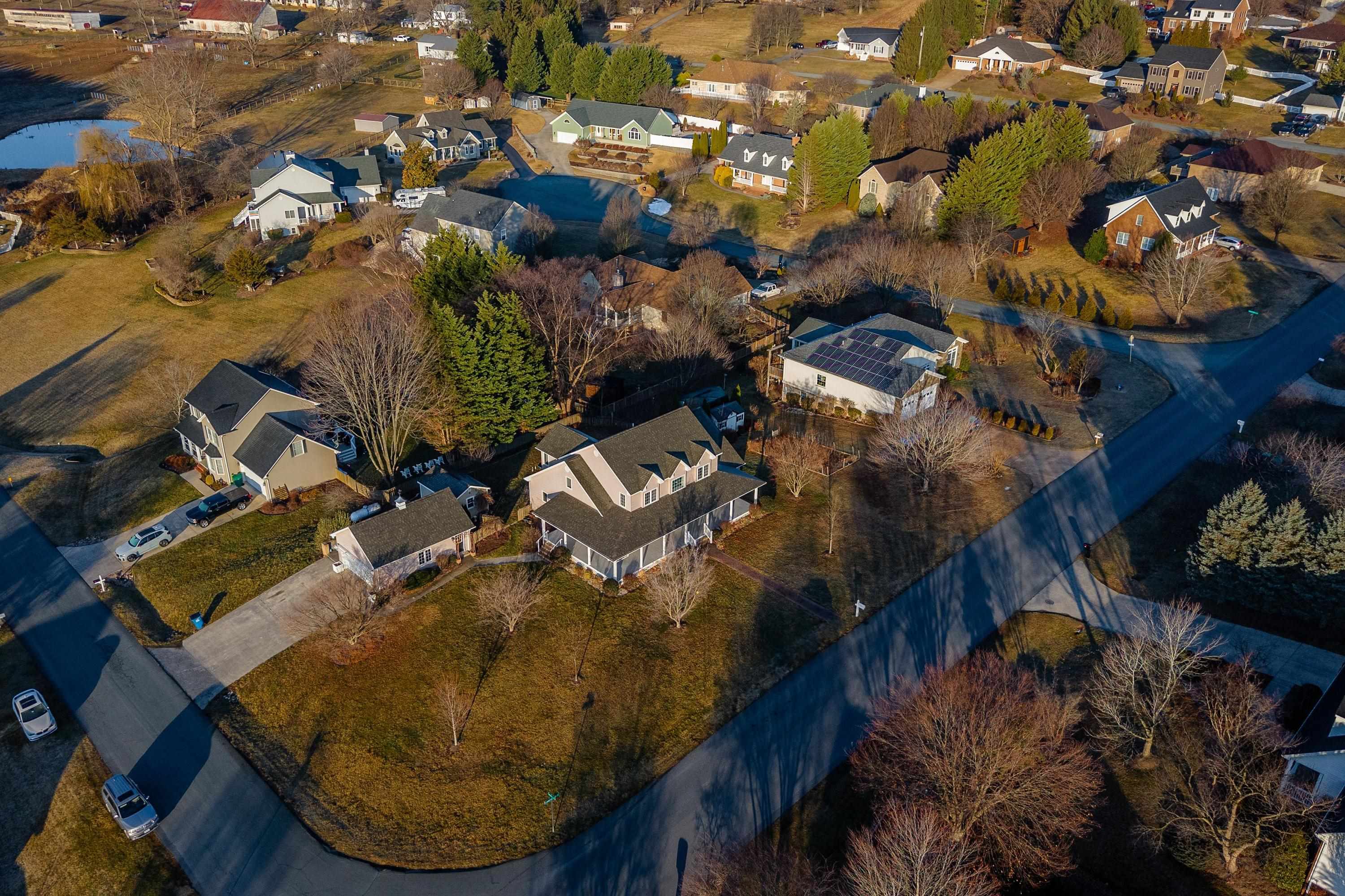 The aerial view highlights the large, level lot of the home, surrounding neighborhood of Battlefield Estates, nearby mountain views, and much more!