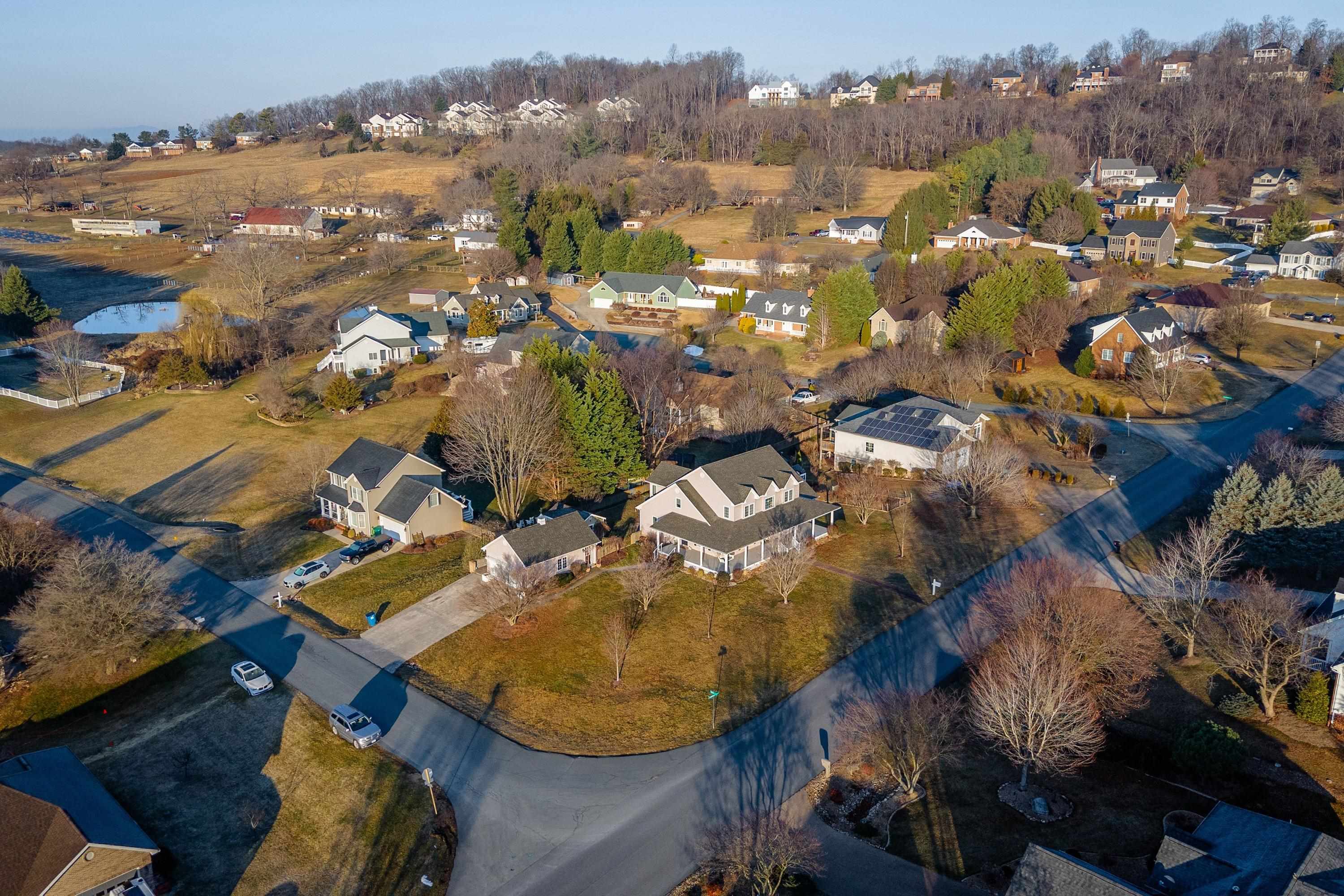 The aerial view highlights the large, level lot of the home, surrounding neighborhood of Battlefield Estates, nearby mountain views, and much more!
