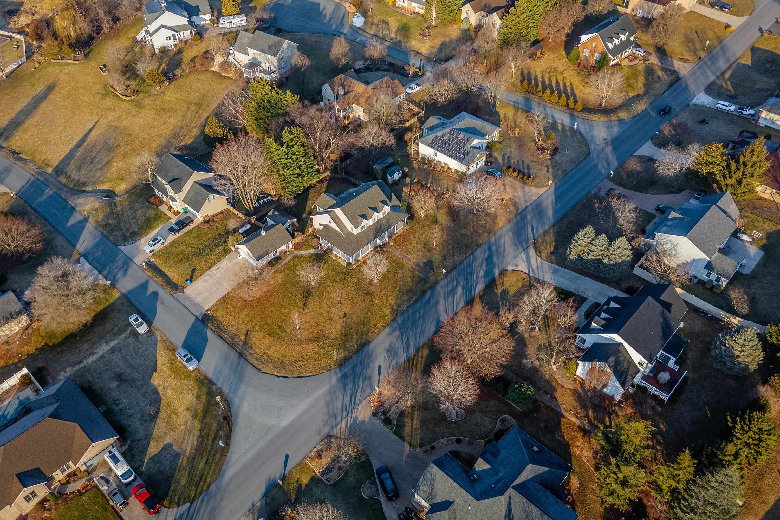 The aerial view highlights the large, level lot of the home, surrounding neighborhood of Battlefield Estates, nearby mountain views, and much more!