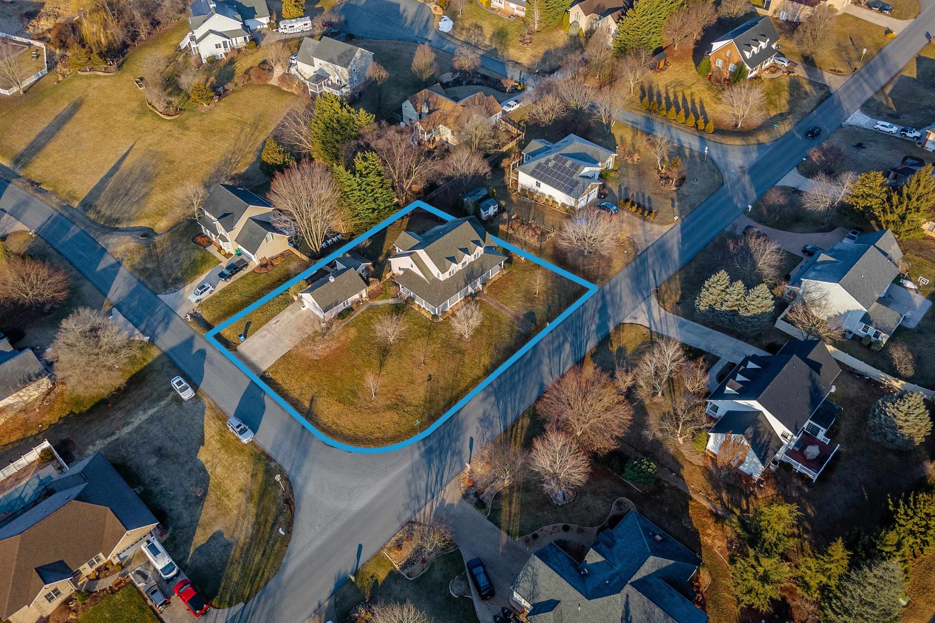The aerial view highlights the large, level lot of the home, surrounding neighborhood of Battlefield Estates, nearby mountain views, and much more!