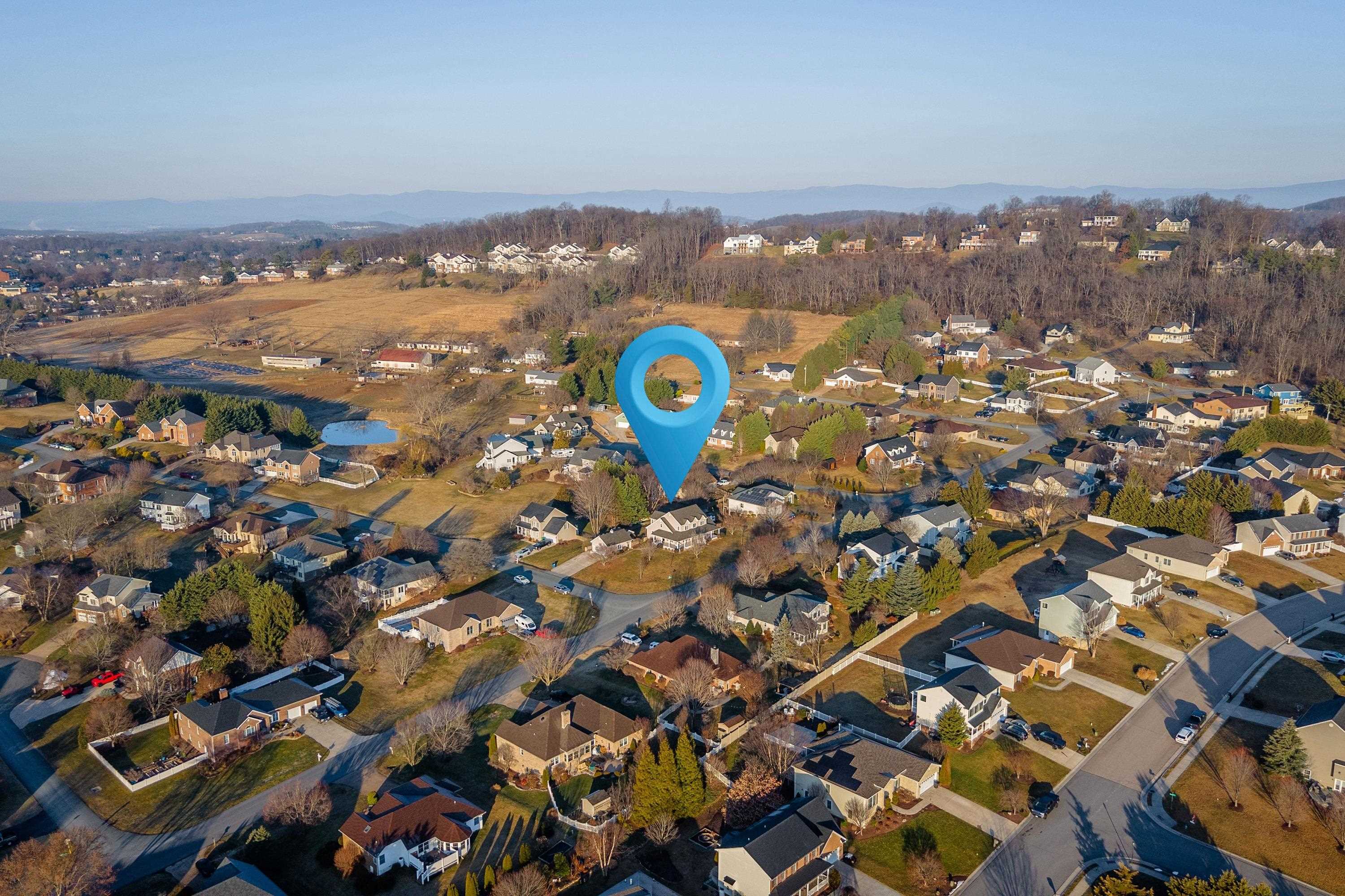 The aerial view highlights the large, level lot of the home, surrounding neighborhood of Battlefield Estates, nearby mountain views, and much more!