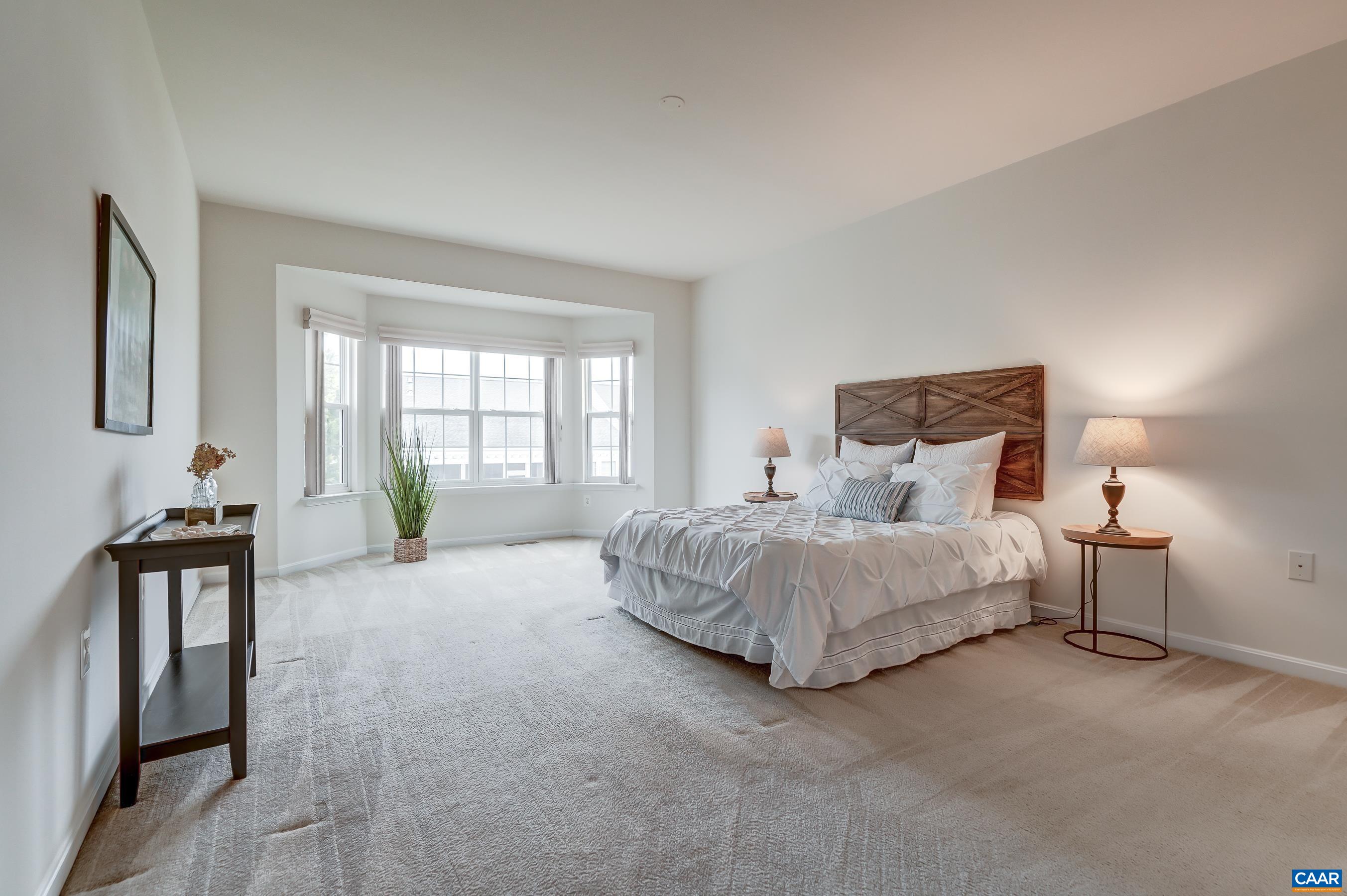 Primary bedroom on the main level with large bay window.