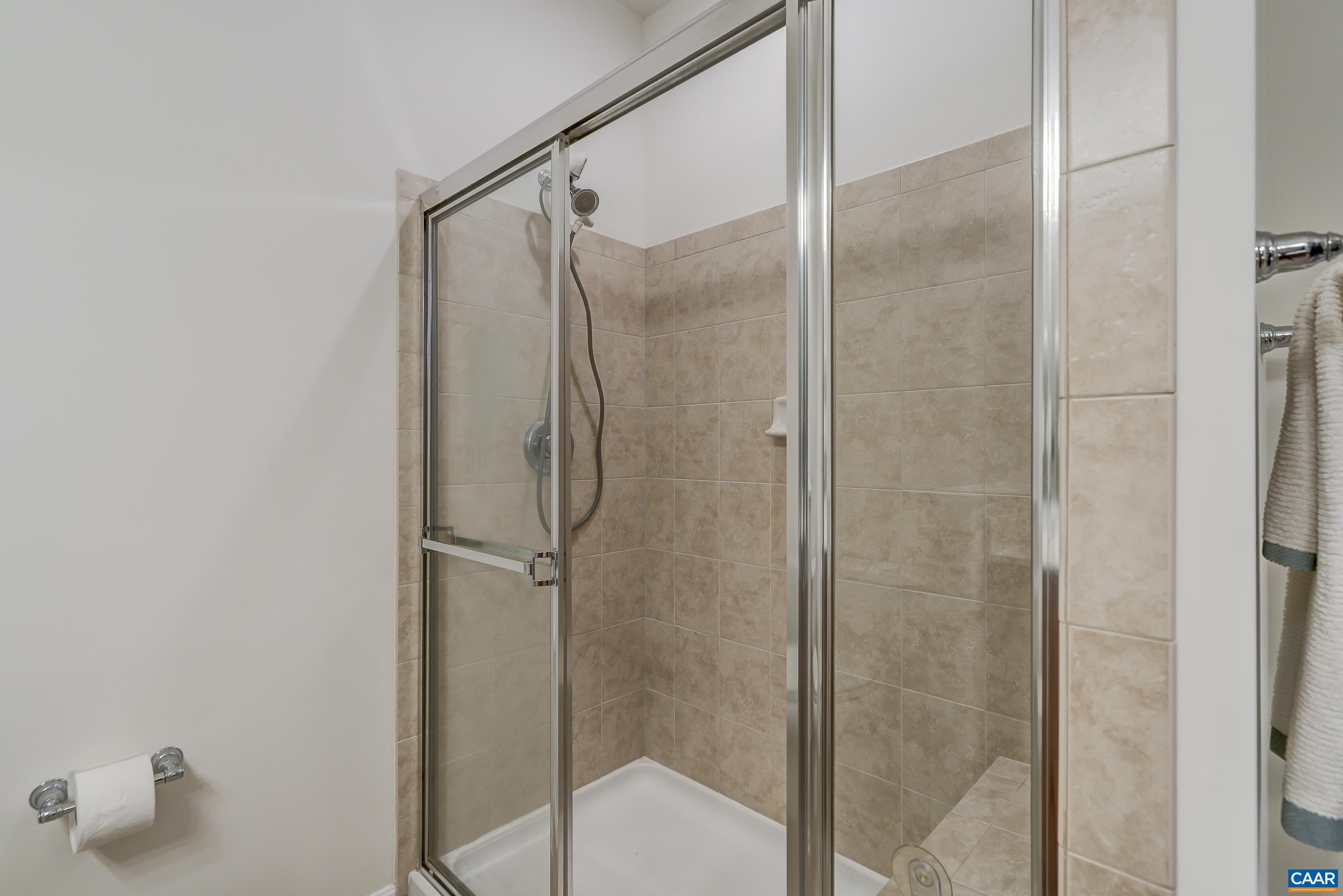 Tiled shower with bench seating.
