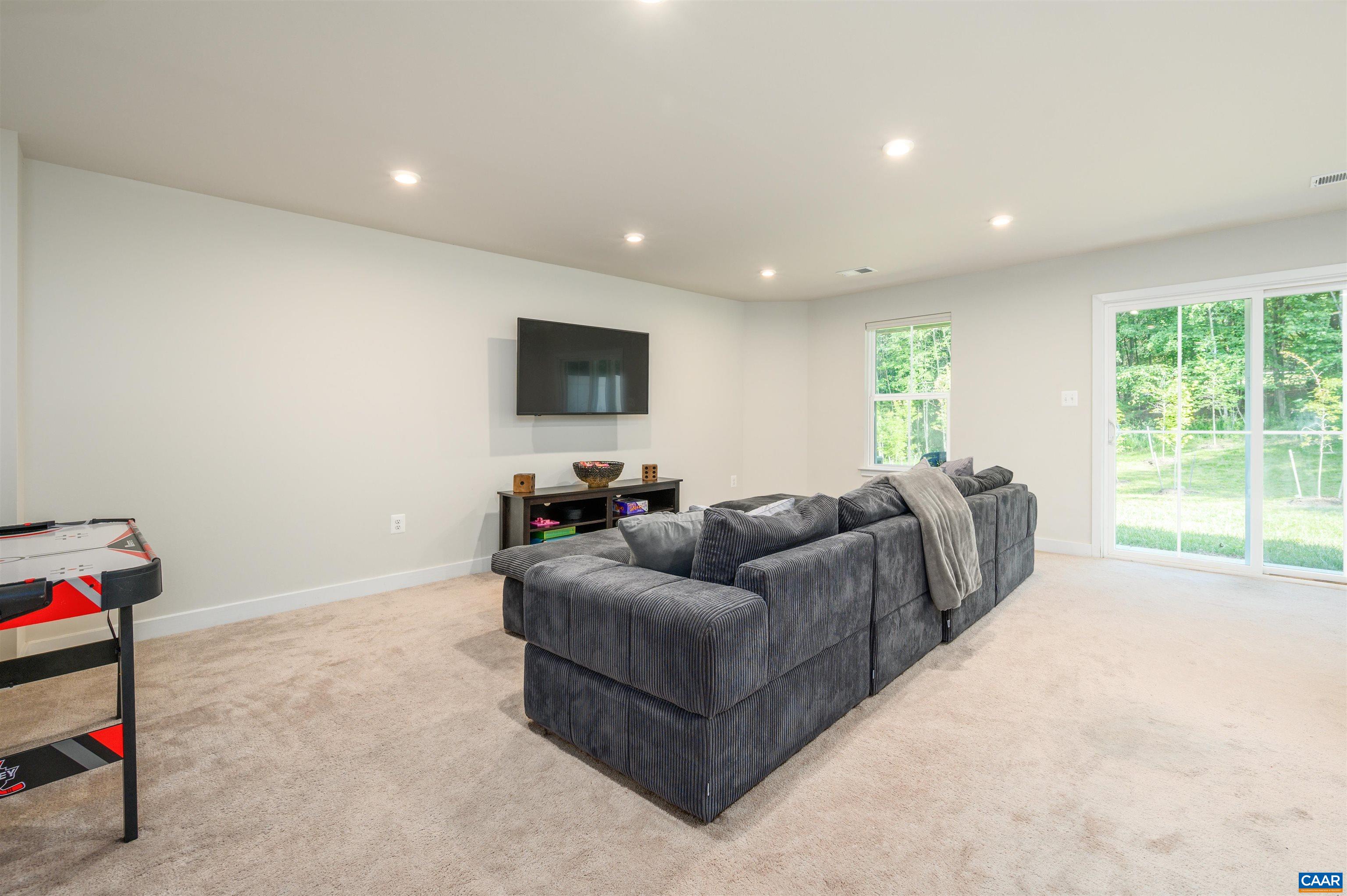 Expansive lower-level recreation room with plush carpet, recessed lighting, and direct access to the backyard. Ideal for movie nights, a home gym, or game-day gatherings.