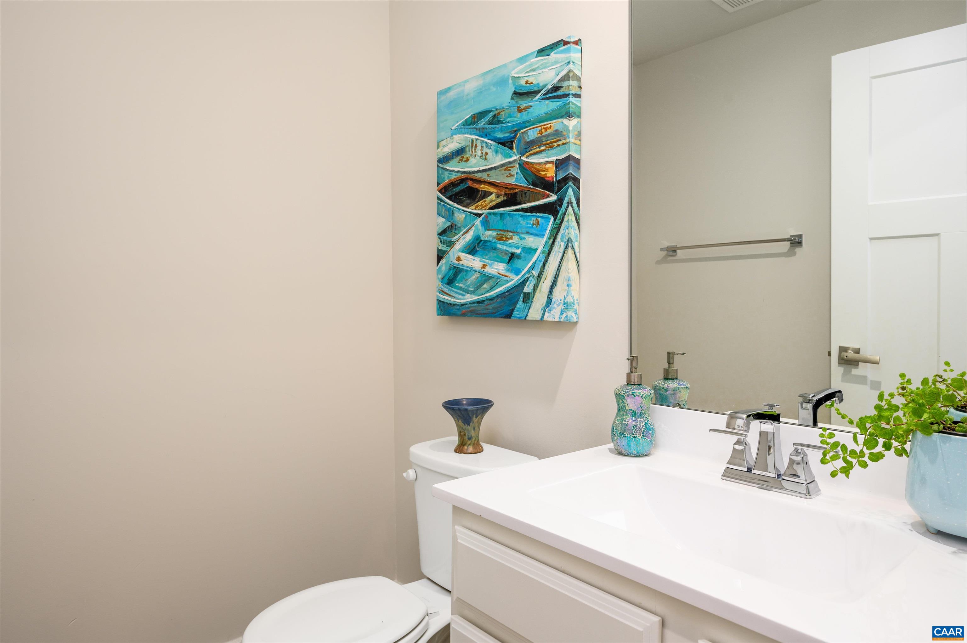Convenient lower-level half bath featuring a clean, modern vanity with sleek fixtures and a large mirror, perfectly positioned to serve the finished walkout terrace level.