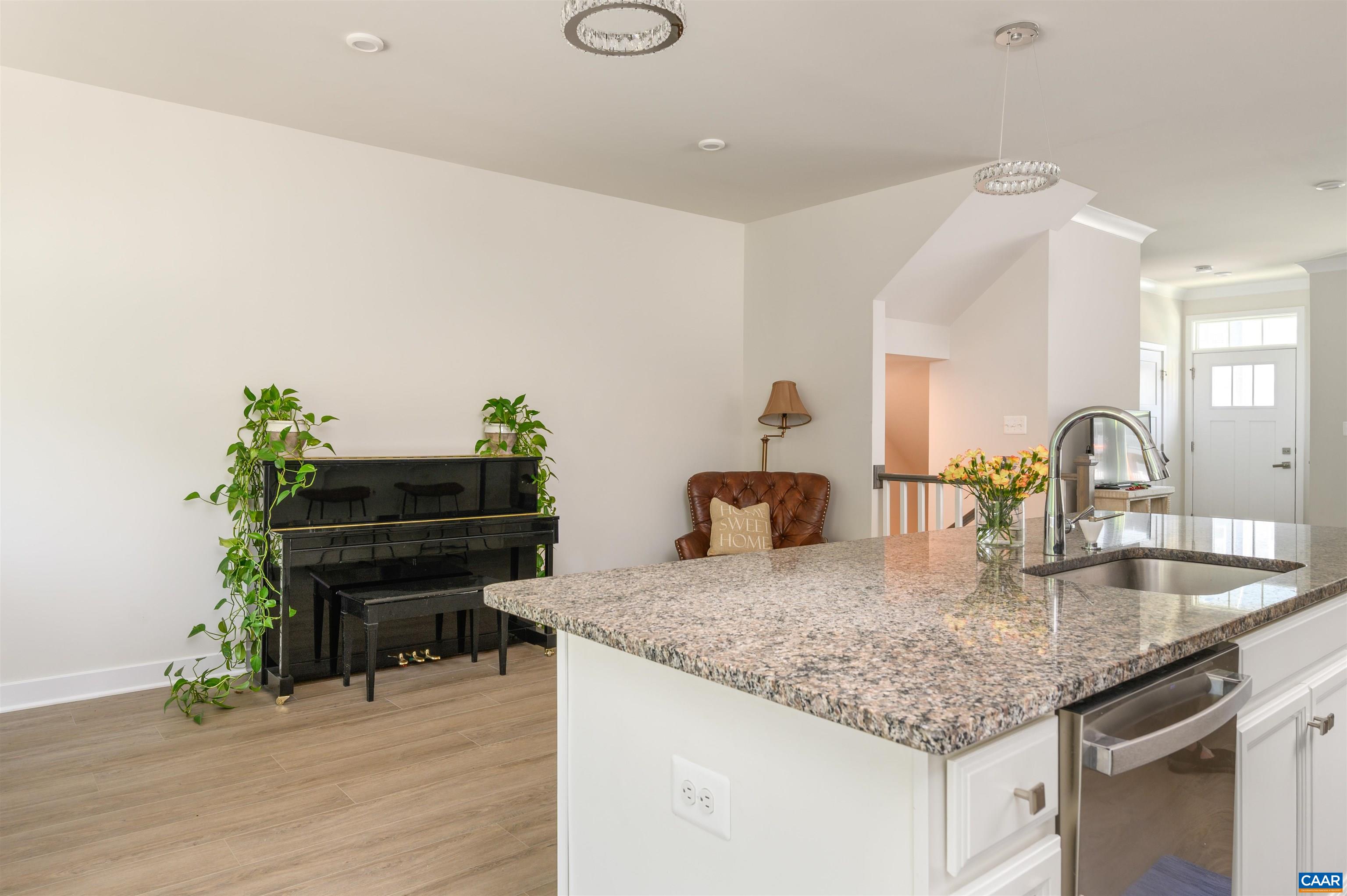 Well-appointed kitchen with granite countertops, stainless steel appliances, gas range, and large island with bar seating.