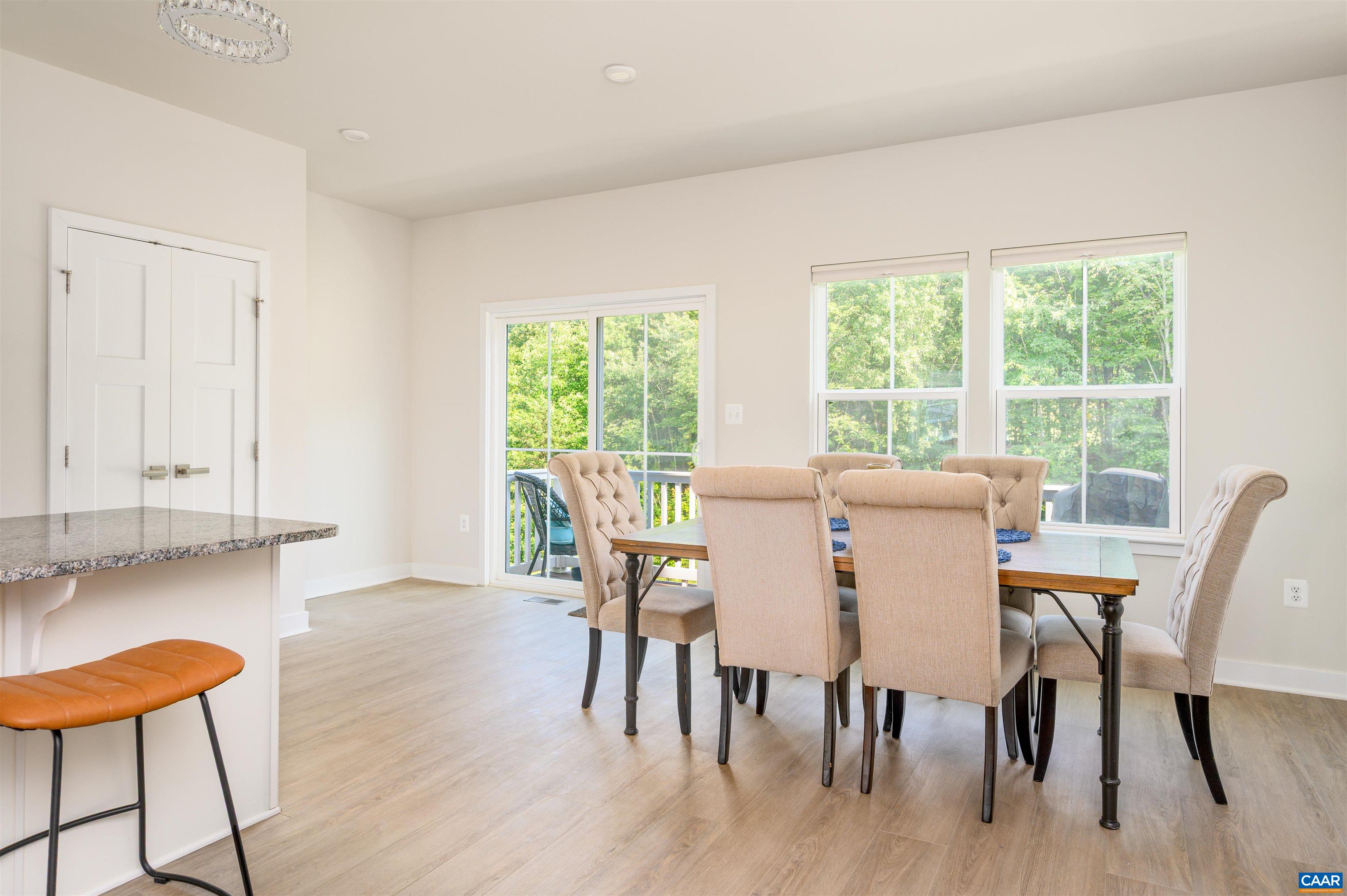 Light-filled dining space with large windows and access to the deck, creating an inviting setting for everyday meals or entertaining.