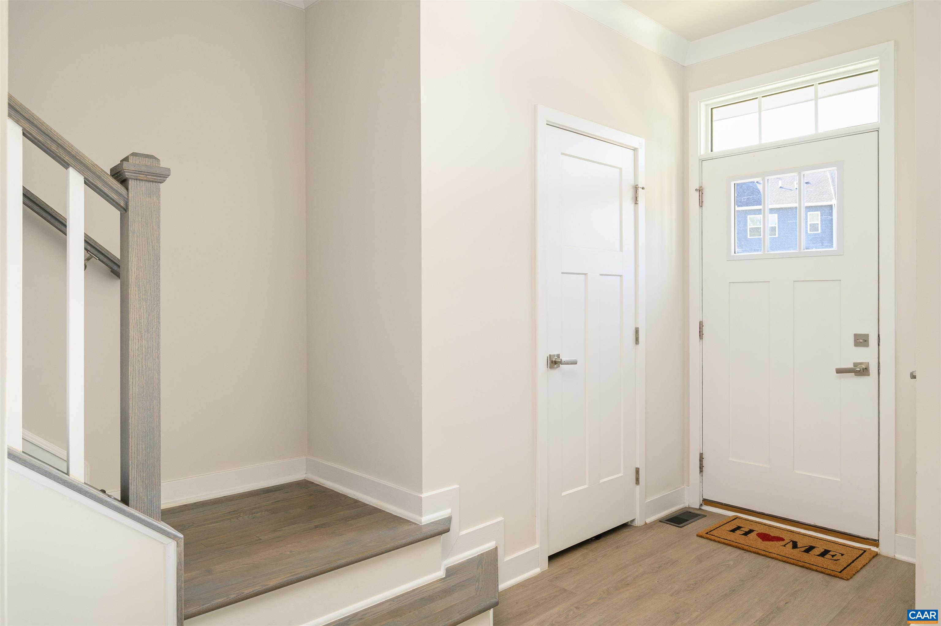 Welcoming front entrance with natural light, transom window for everyday ease with a coat closet. Convenient main-level half bath located just off the living space, ideal for guests.