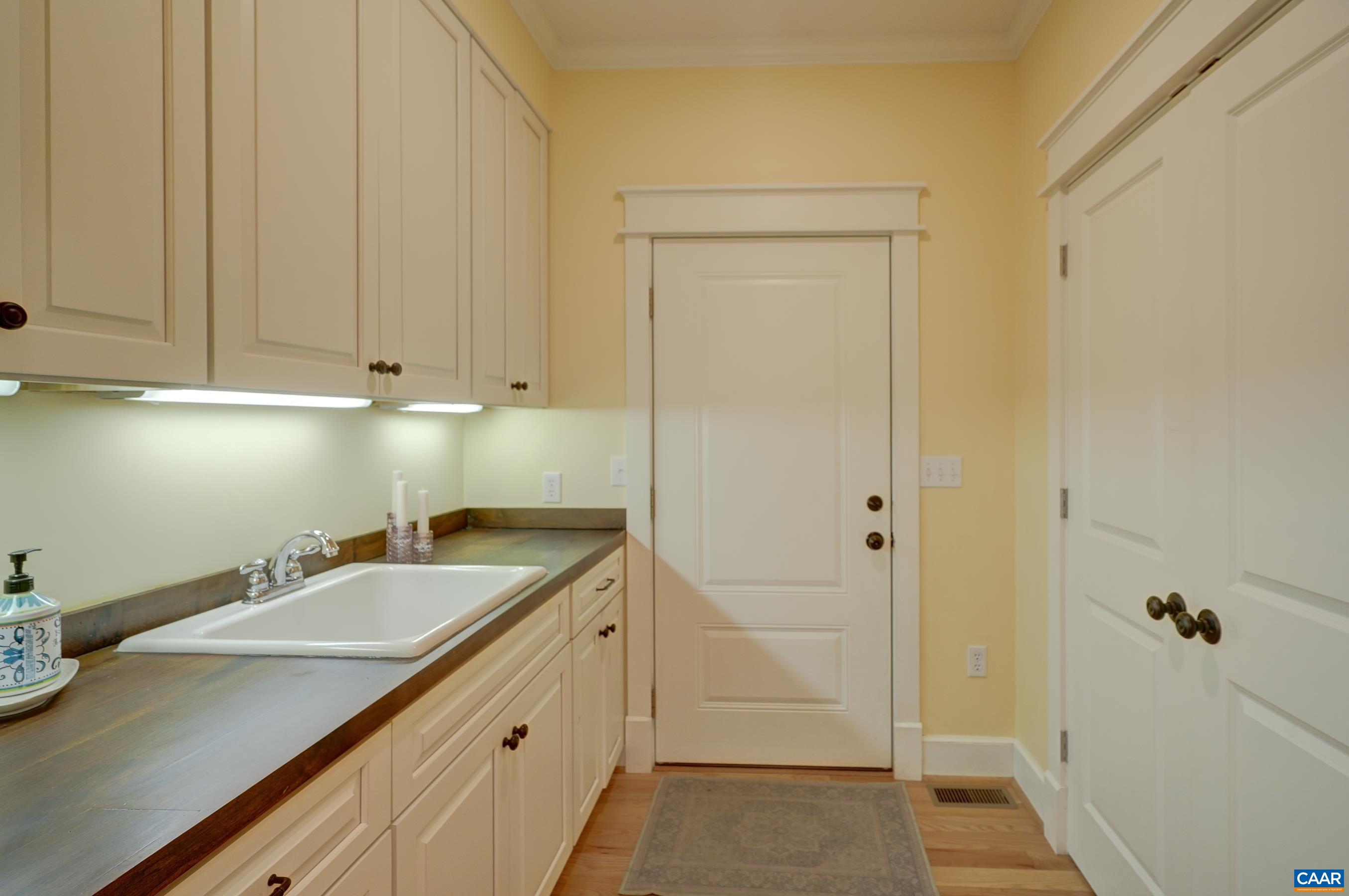 Mudroom with utility sink and extra storage.