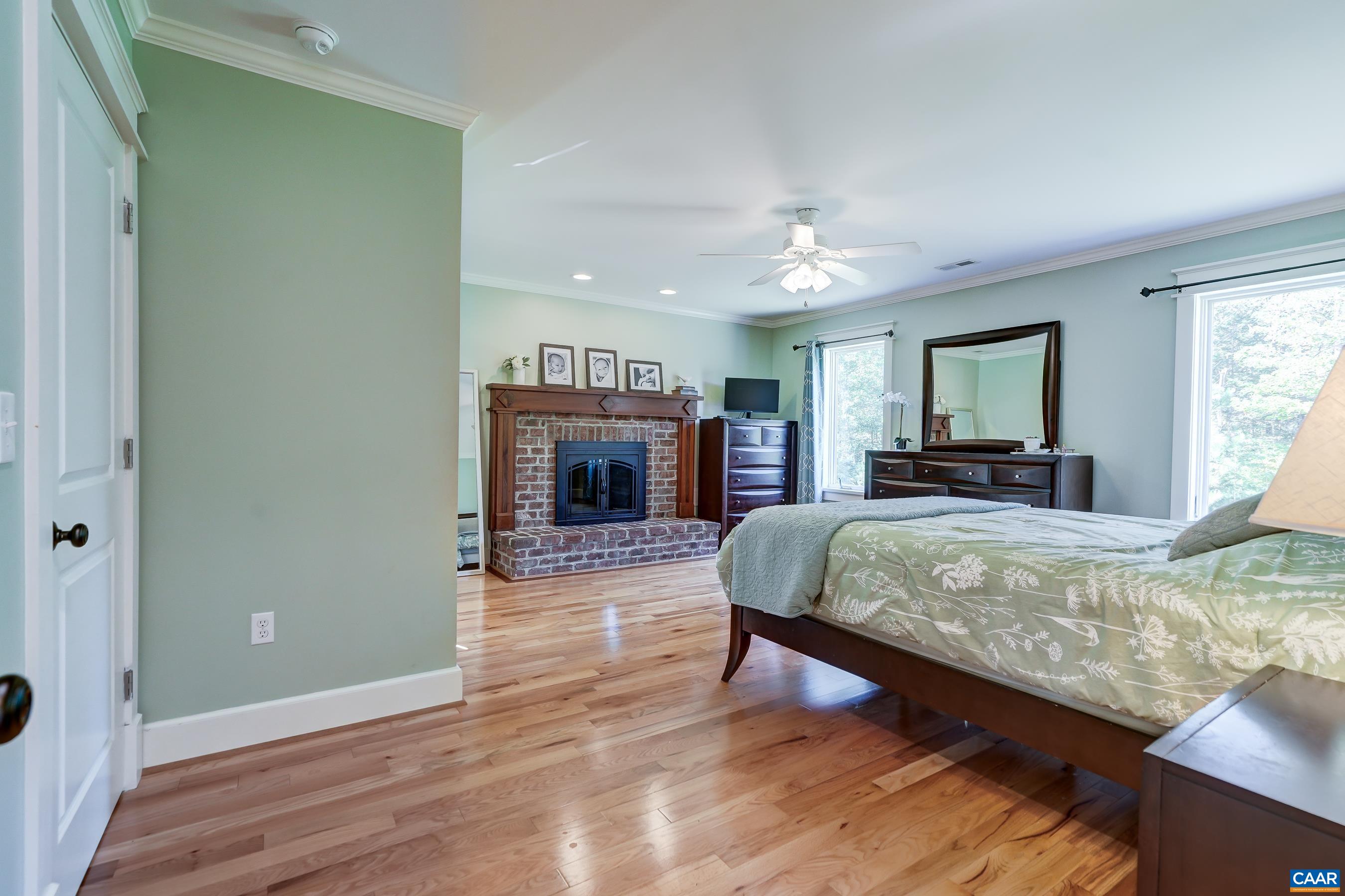 Primary bedroom on second floor features cherry hardwood floors and a brick wood-burning fireplace.