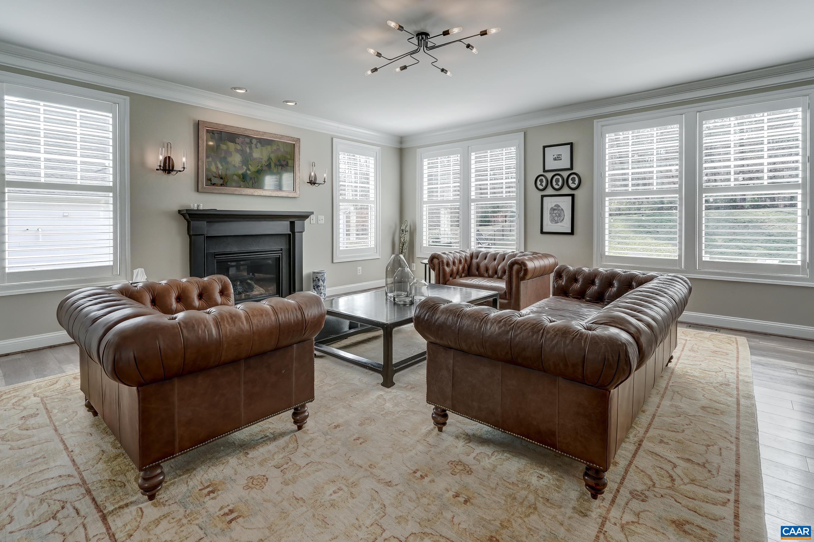 Light-filled great room with gas fireplace and modern light fixture.