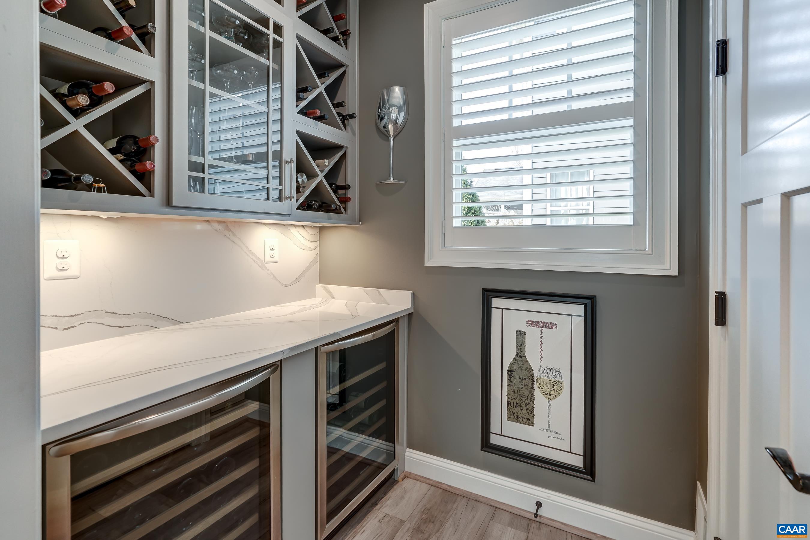 Custom built wine bar features so much storage plus two under cabinet wine coolers.