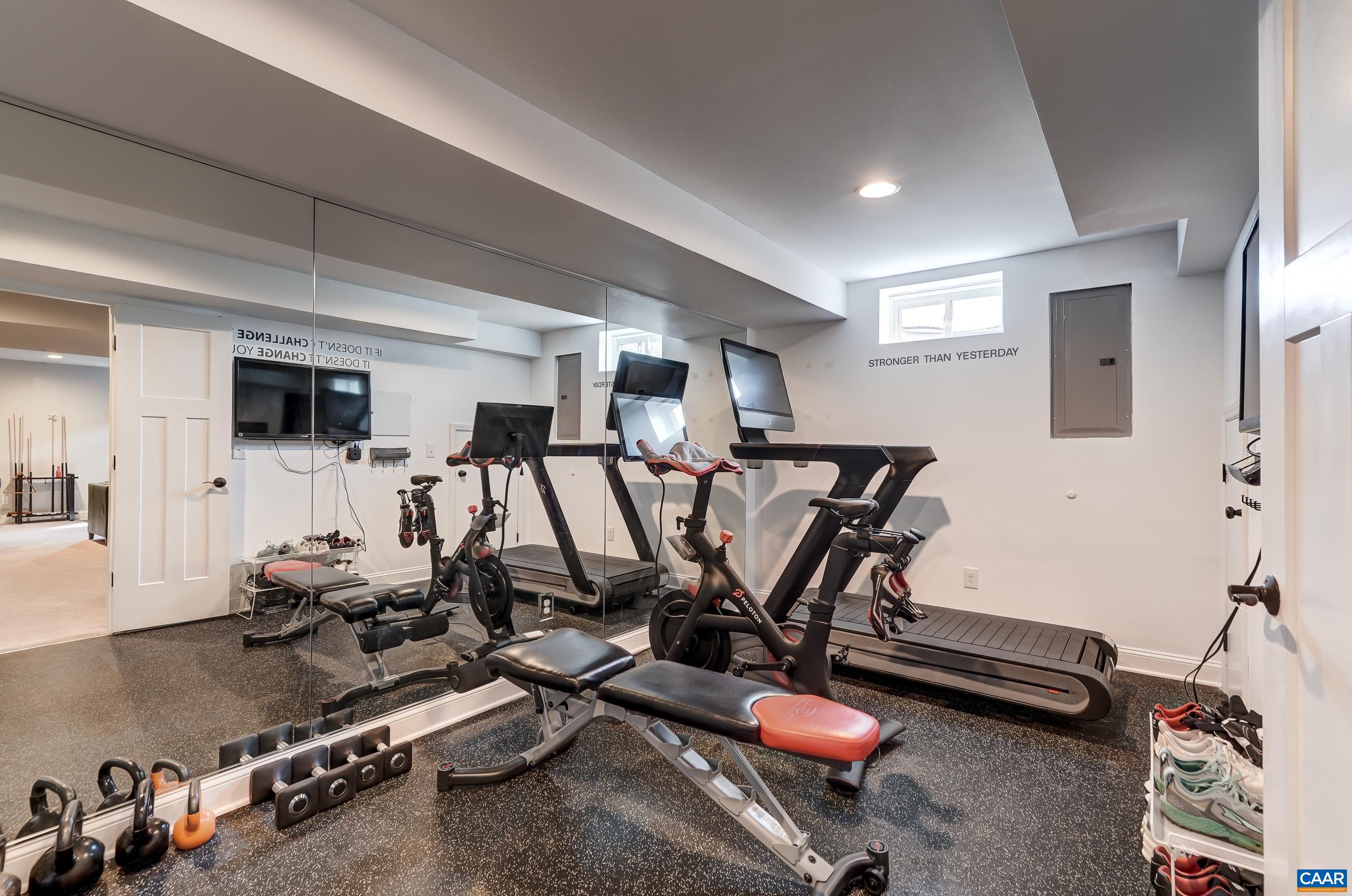 Workout at home in the beautiful home gym with mirrored wall and rubber flooring.