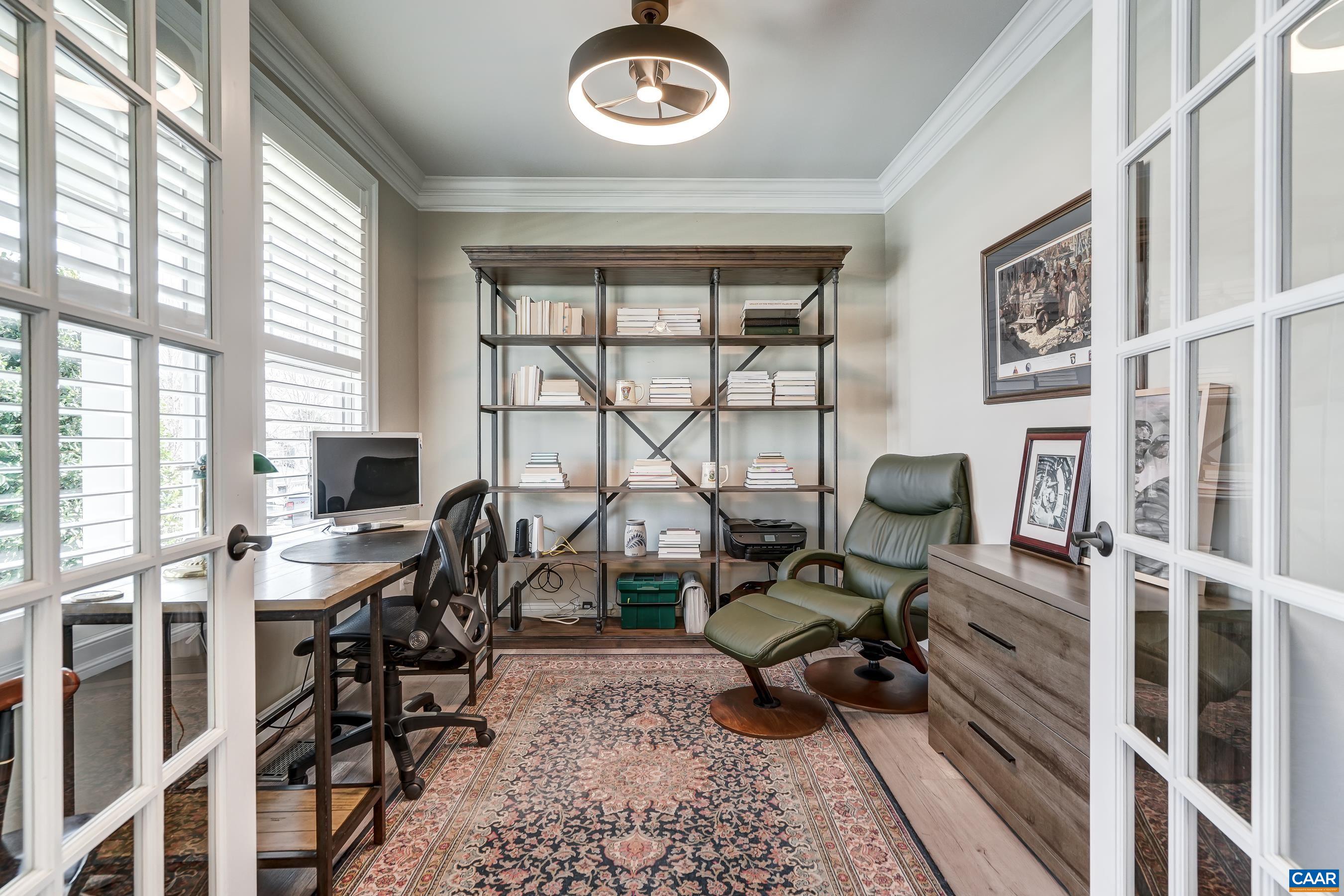 Home office with French doors for privacy and modern light fixture/fan