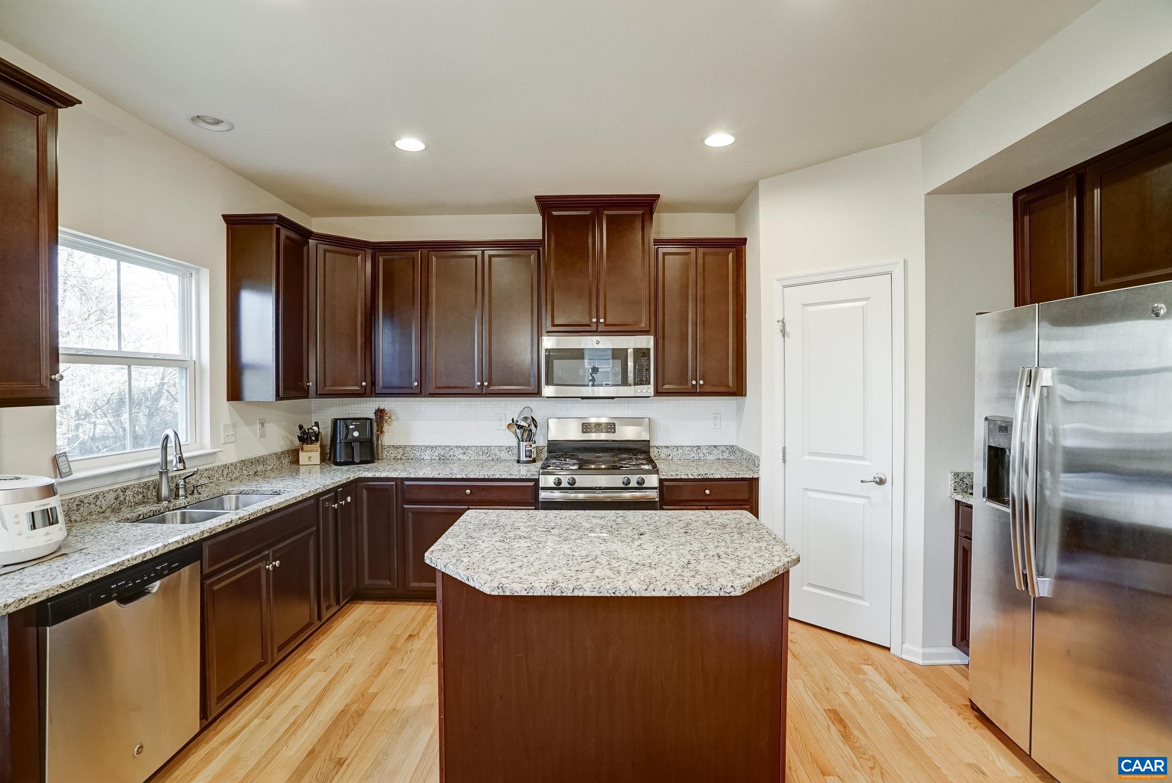 Kitchen features a large central island with granite countertop - a great prep surface!