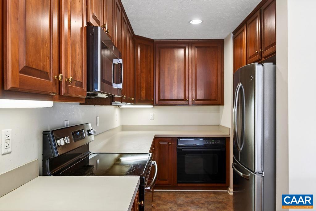 Wonderful kitchen featuring cherry counter tops and stainless steel appliances.