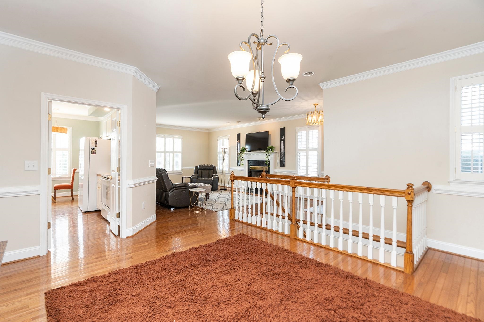 ...into Family room, Kitchen, and view of stairs to the lower level.