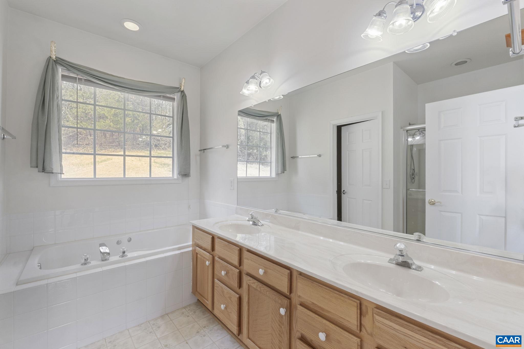 Primary bath with soaking tub, double sink vanity, walk in shower.