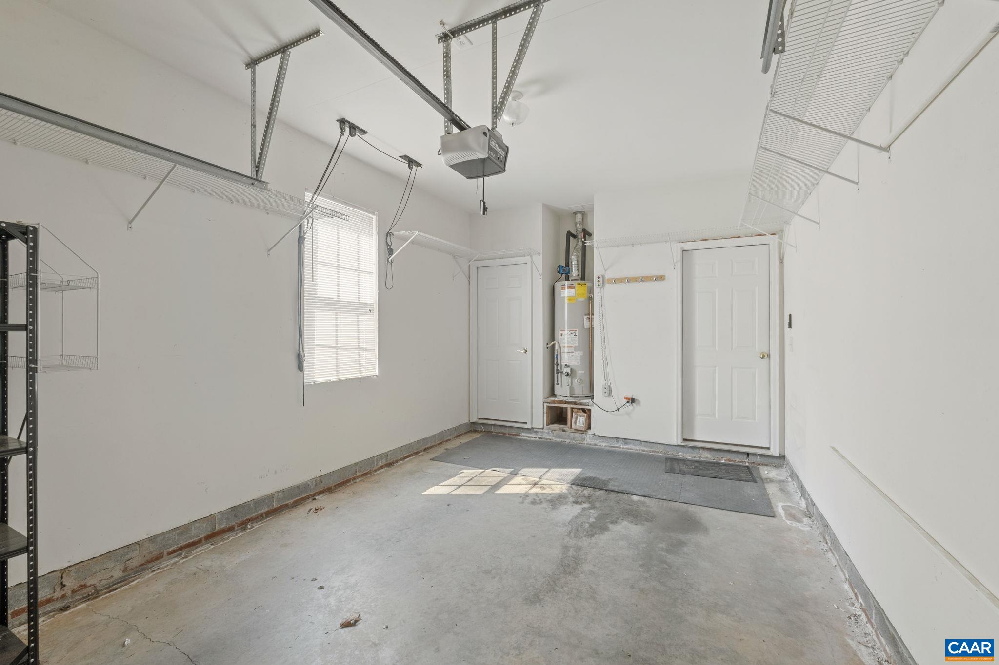 Garage with auto door, window, and utility closet at back.