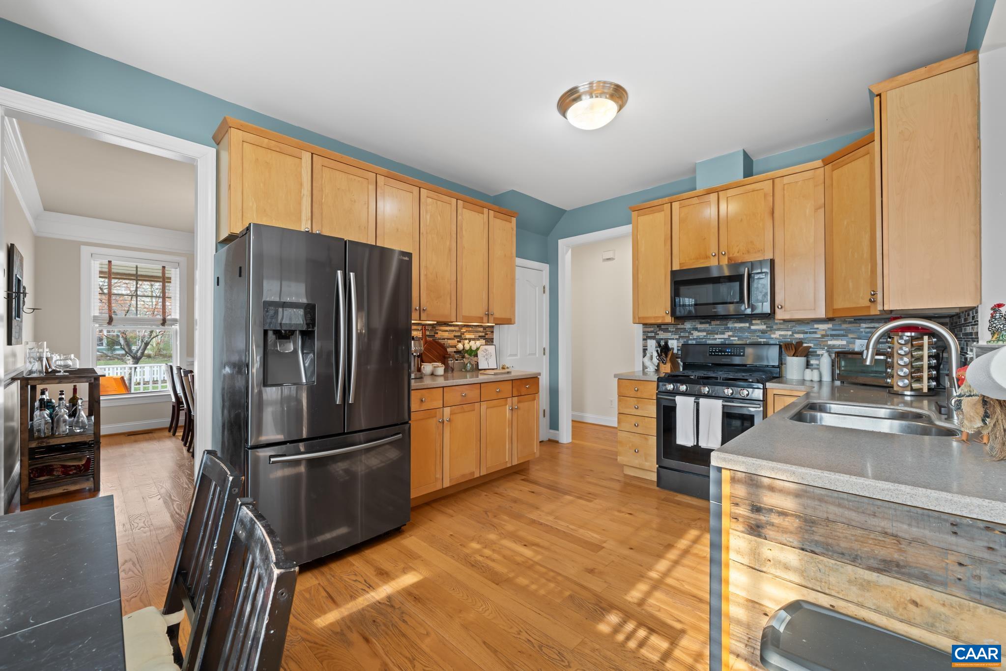 Functional kitchen featuring maple cabinets, solid surface counters, and a sunny breakfast nook.