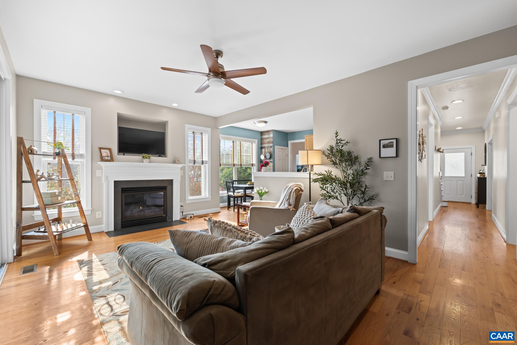 The heart of the home features a cozy gas fireplace with a mantel and large windows for natural light.