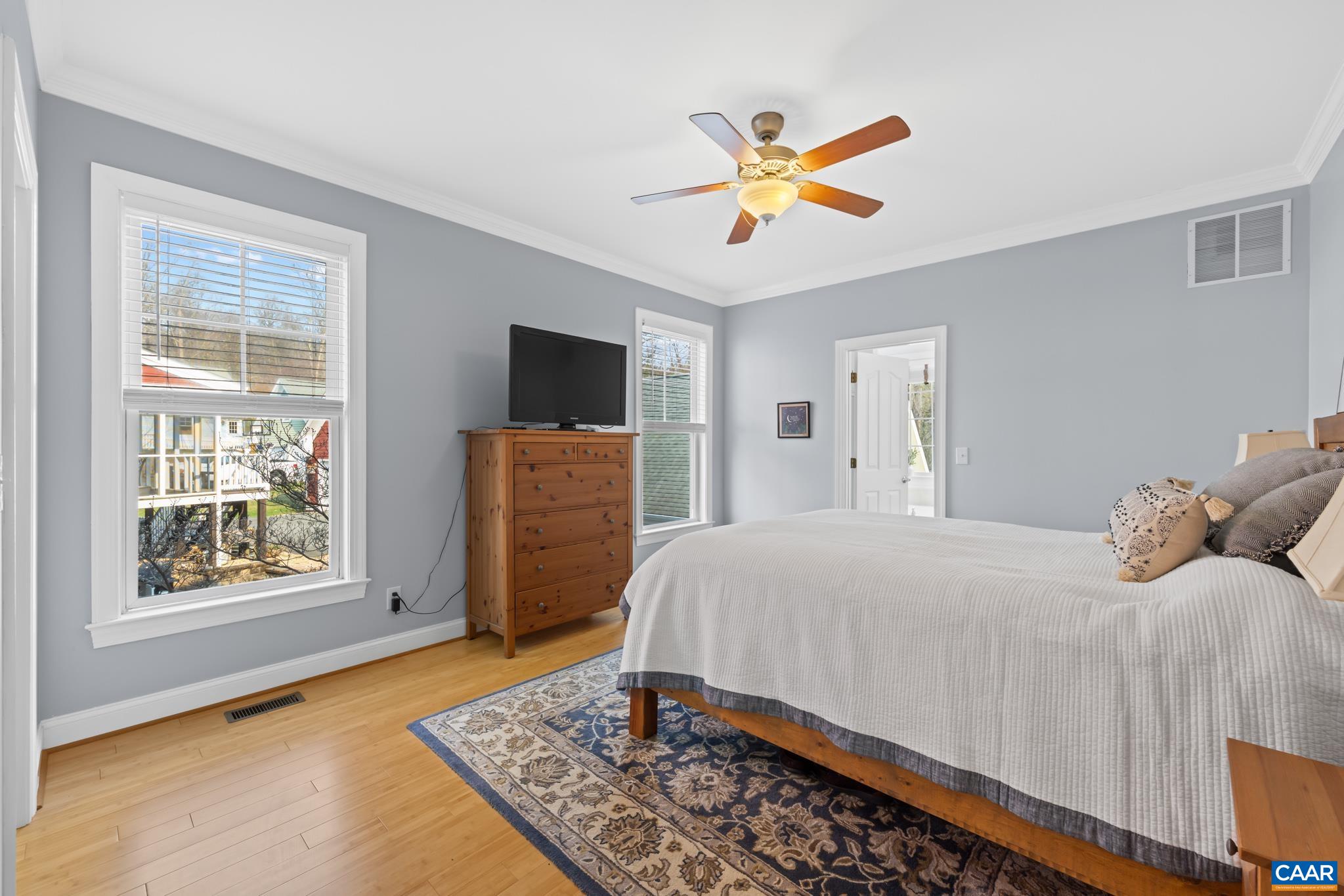 Another view of the primary bedroom with hardwood floors.