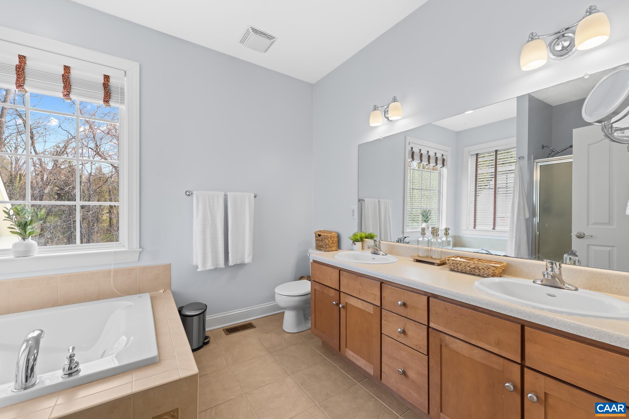 The primary en-suite bath includes dual vanities and a relaxing soaking tub.