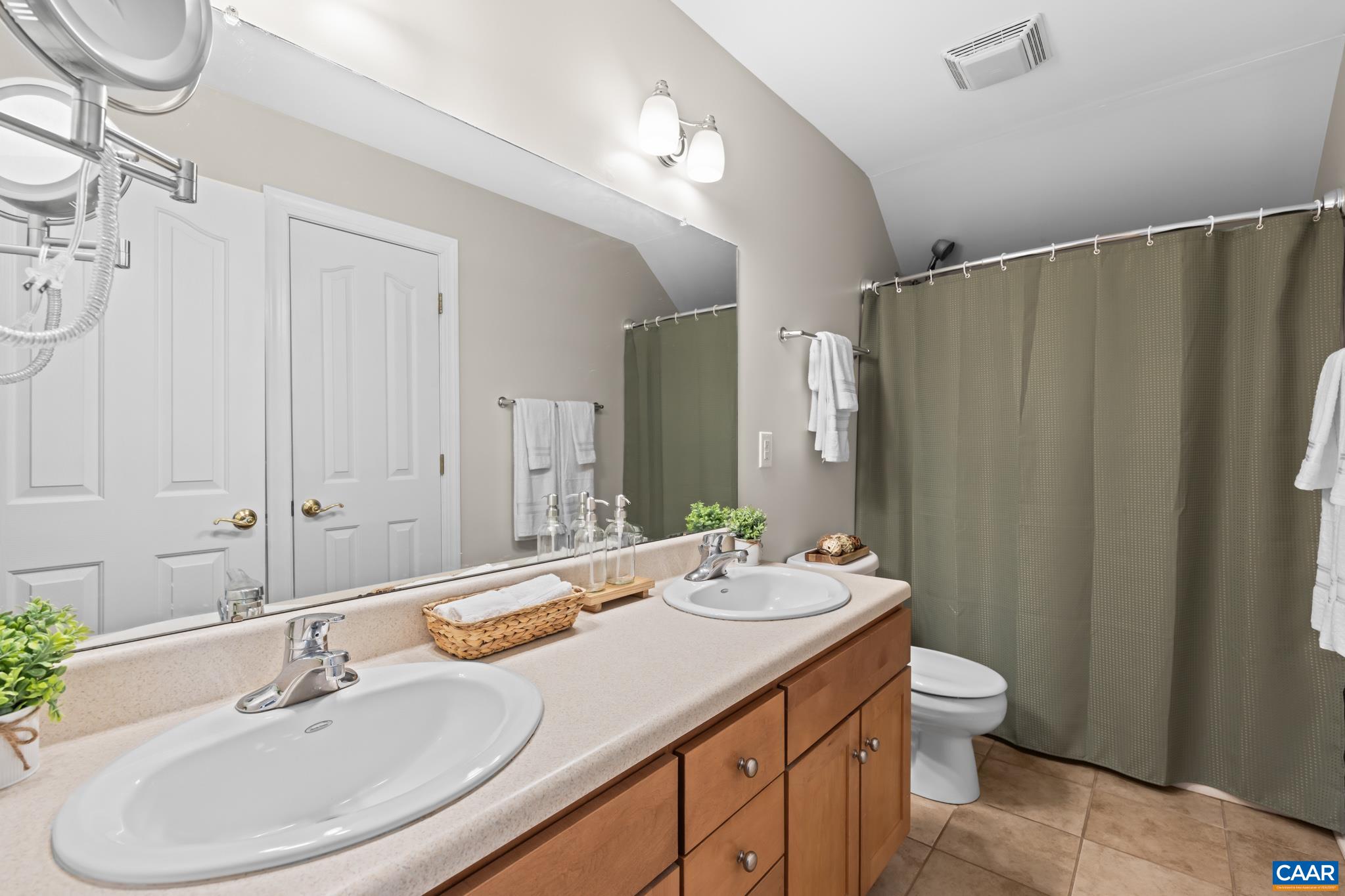 Full bath on the second level with dual vanities and tub shower. Ceramic tile floor.