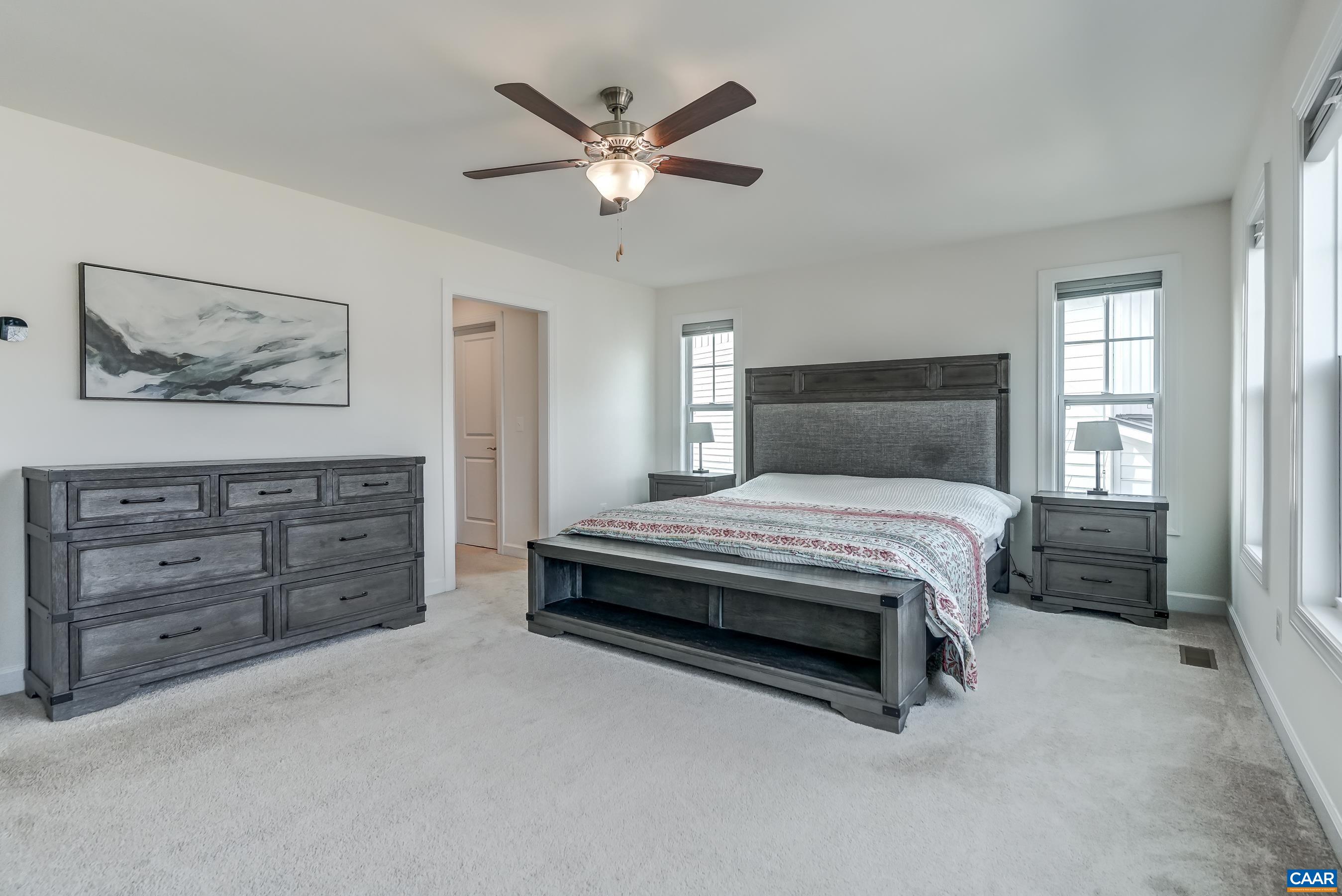 Primary bedroom with ceiling fan.