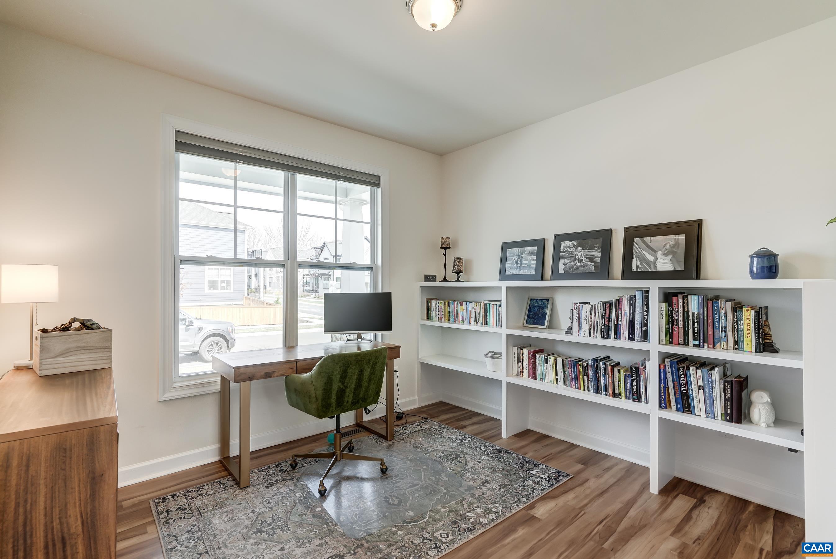 Home office features built-in shelving and could also be a great playroom with storage options!