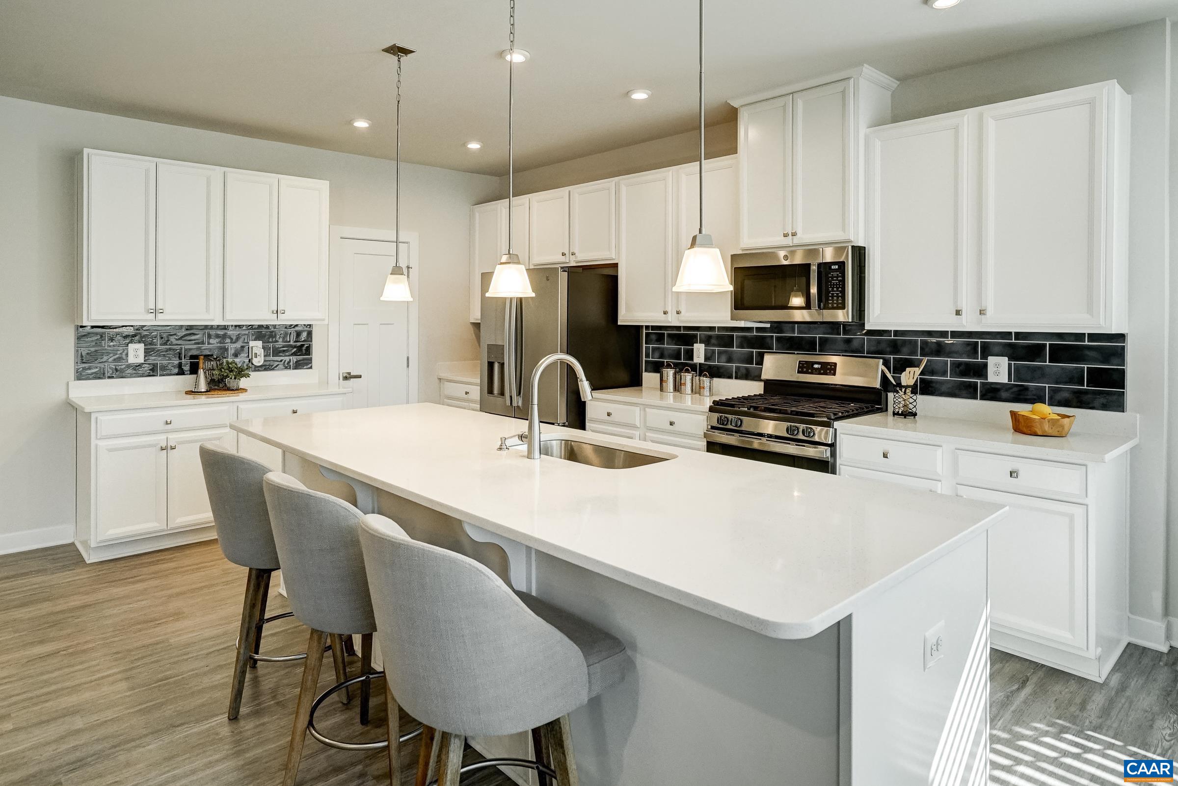 Gourmet kitchen features white cabinets, quartz countertops and a beautiful backsplash. Gourmet kitchen features white cabinets, quartz countertops and a beautiful backsplash.
