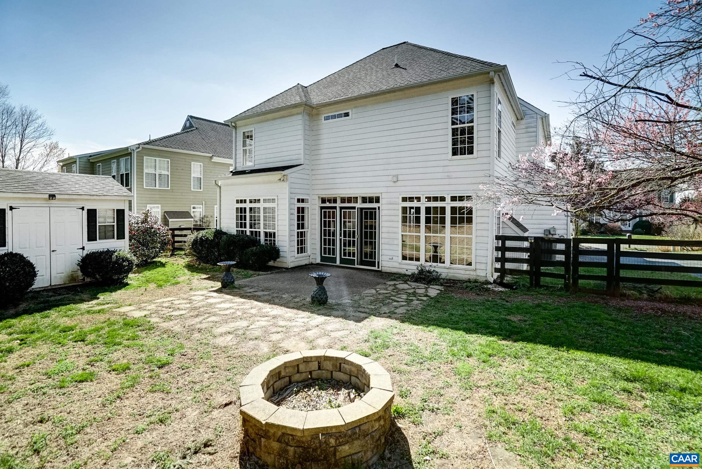 Fenced back yard with fire pit, patio and storage shed. Fenced back yard with fire pit, patio and storage shed.
