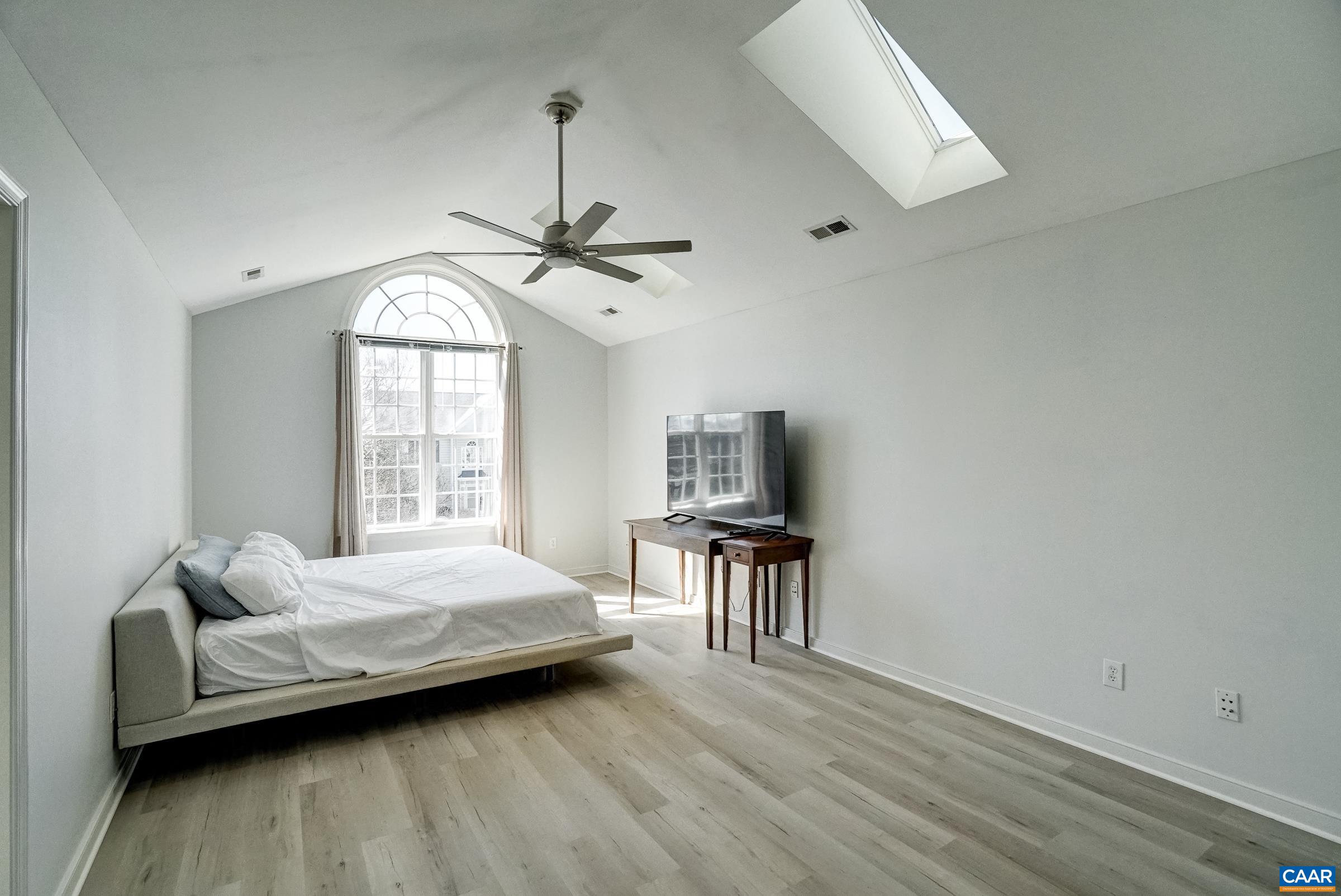Primary bedroom with new LVP flooring (2026) vaulted ceiling and skylights! Primary bedroom with new LVP flooring (2026) vaulted ceiling and skylights!
