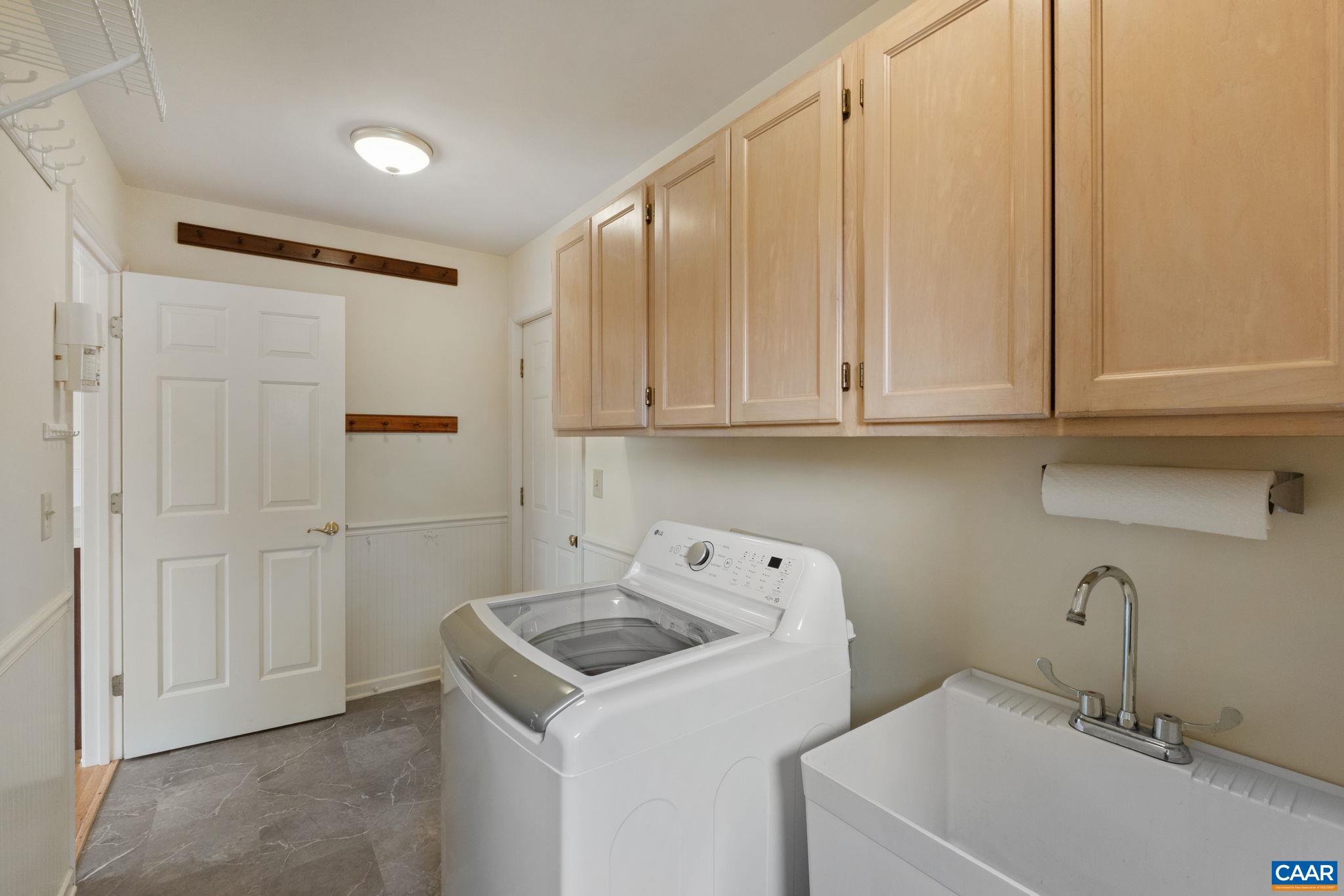 With washer, dryer, laundry sink, cabinets, coat hooks, and closet the mudroom offers the perfect landing spot for entry from the garage to the kitchen.