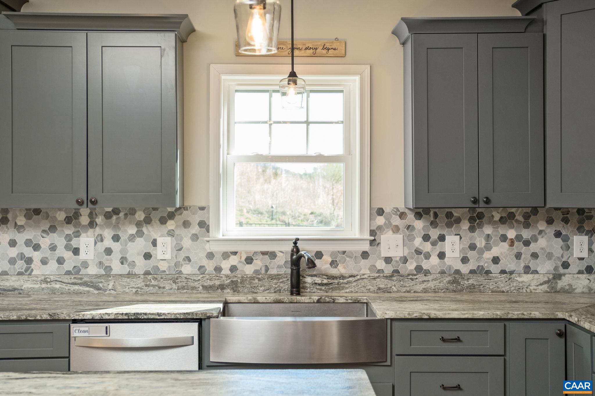 Farmhouse sink with window to enjoy the views. The tile backsplash is also in view. Farmhouse sink with window to enjoy the views. The tile backsplash is also in view.