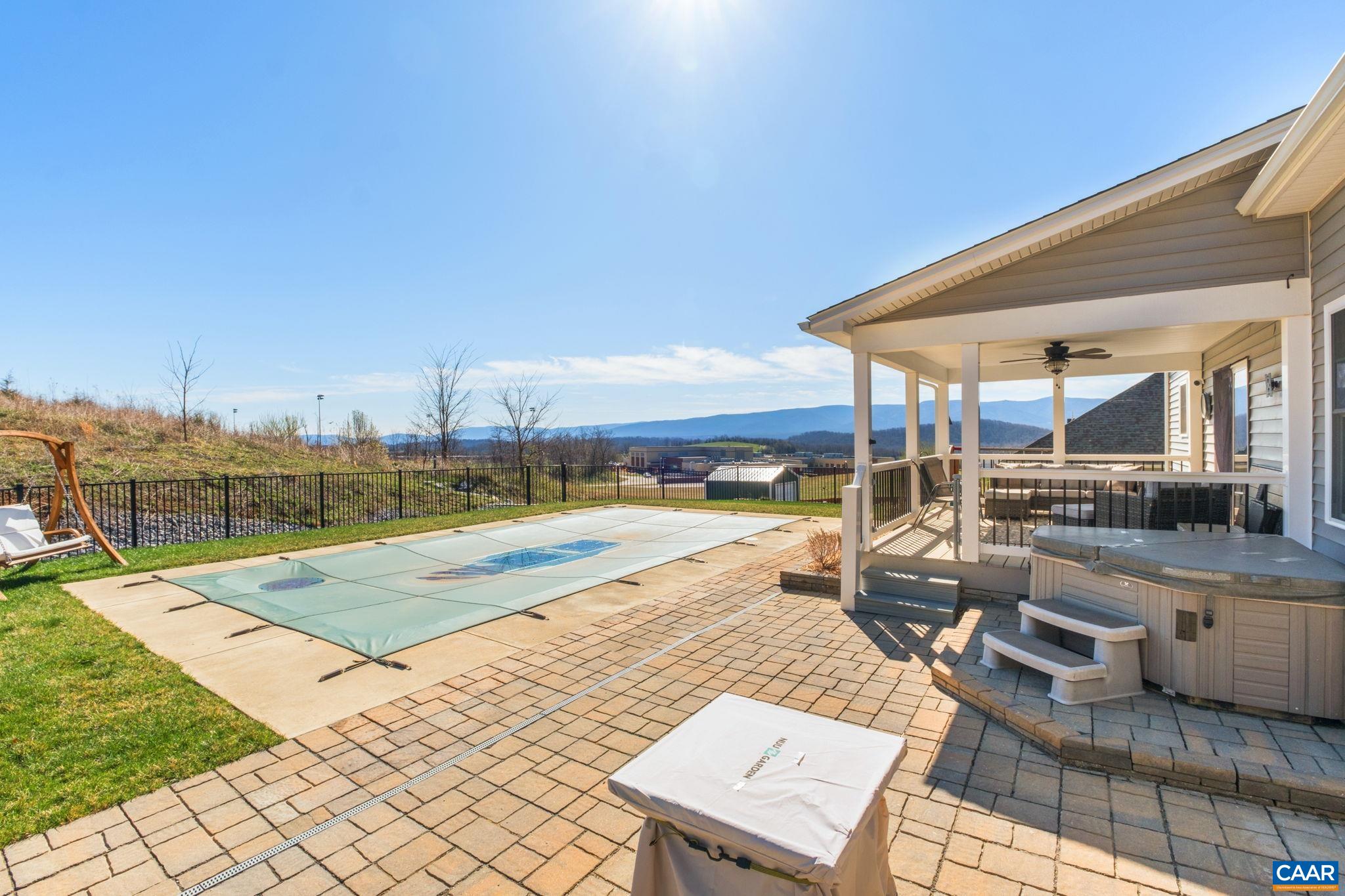 The straps for the pool safety cover are also in view. The saltwater pool is heated. A retaining wall was added to level off the backyard, and French drains and swells were added for peace of mind. The straps for the pool safety cover are also in view. The saltwater pool is heated. A retaining wall was added to level off the backyard, and French drains and swells were added for peace of mind.