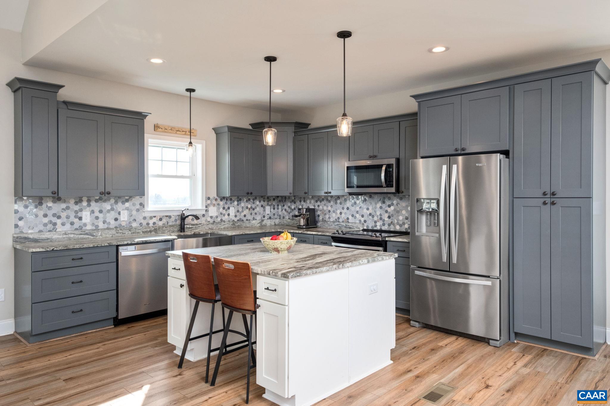 The kitchen and great room are open concept. The kitchen features leathered granite (upgrade), a double island, farmhouse sink, and stainless steel appliances. The kitchen and great room are open concept. The kitchen features leathered granite (upgrade), a double island, farmhouse sink, and stainless steel appliances.