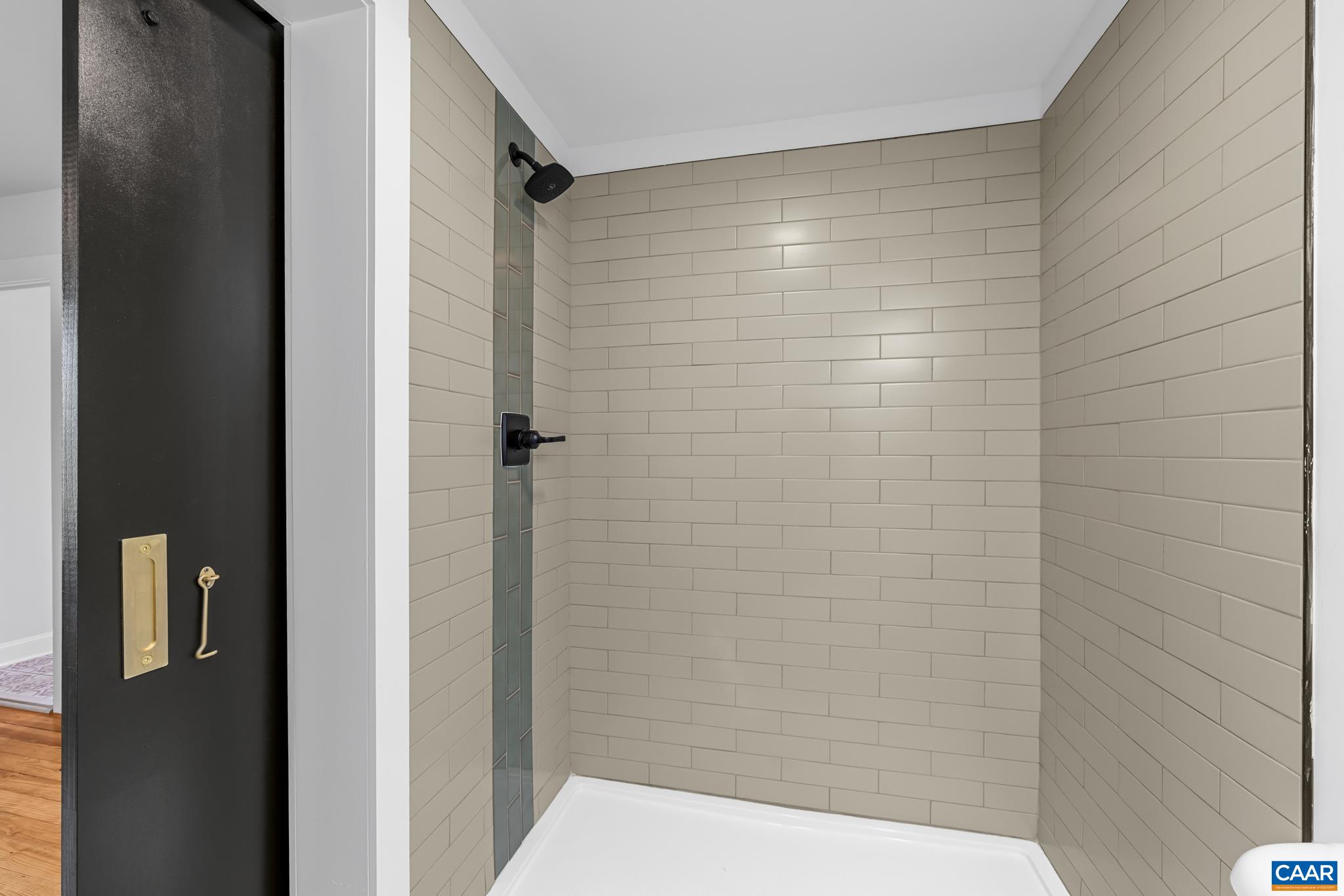 This stunning primary bathroom features all-new fixtures and a beautifully tiled walk-in shower.