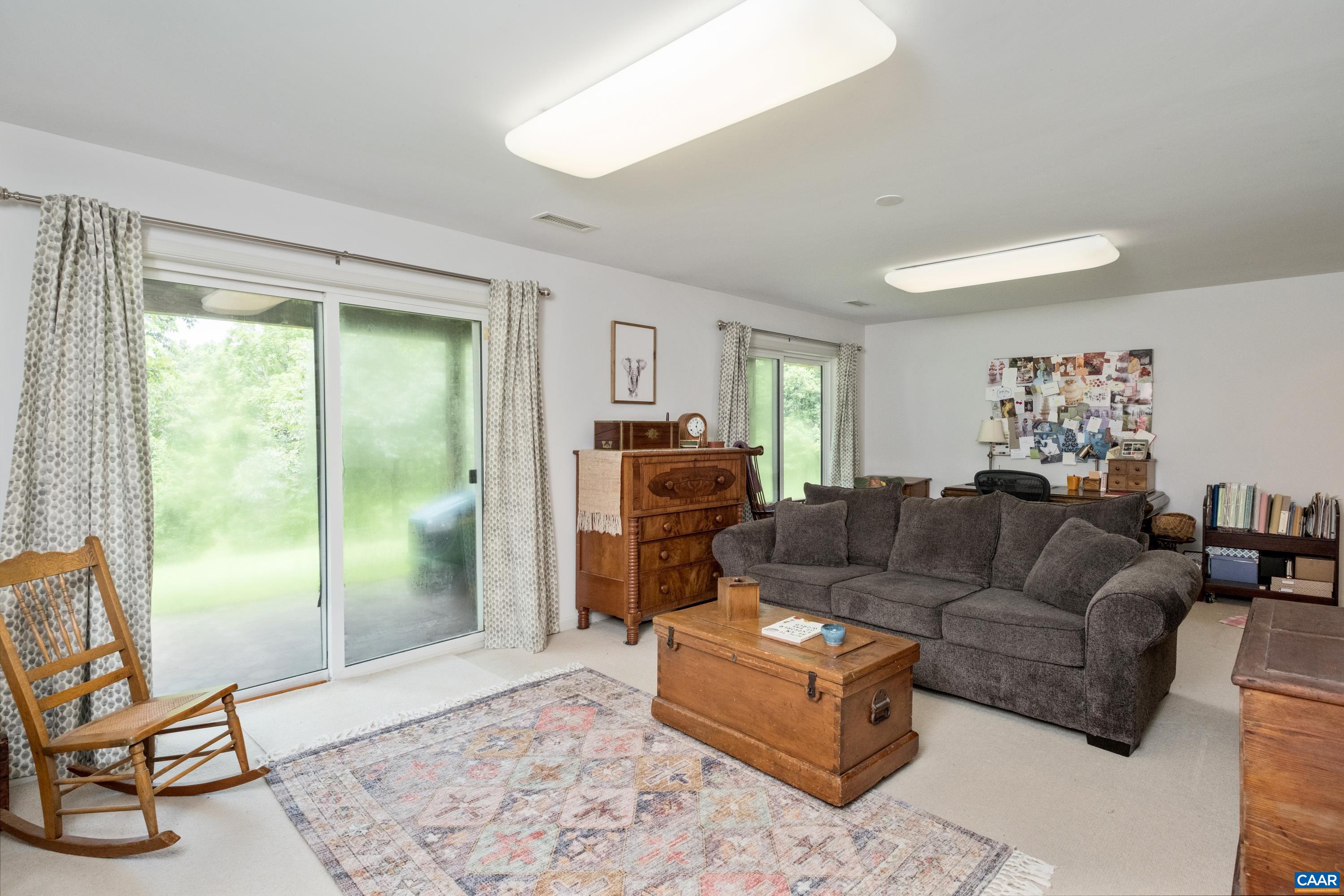 Family room with two separate sliding doors access to outside patio area and green space with pond.