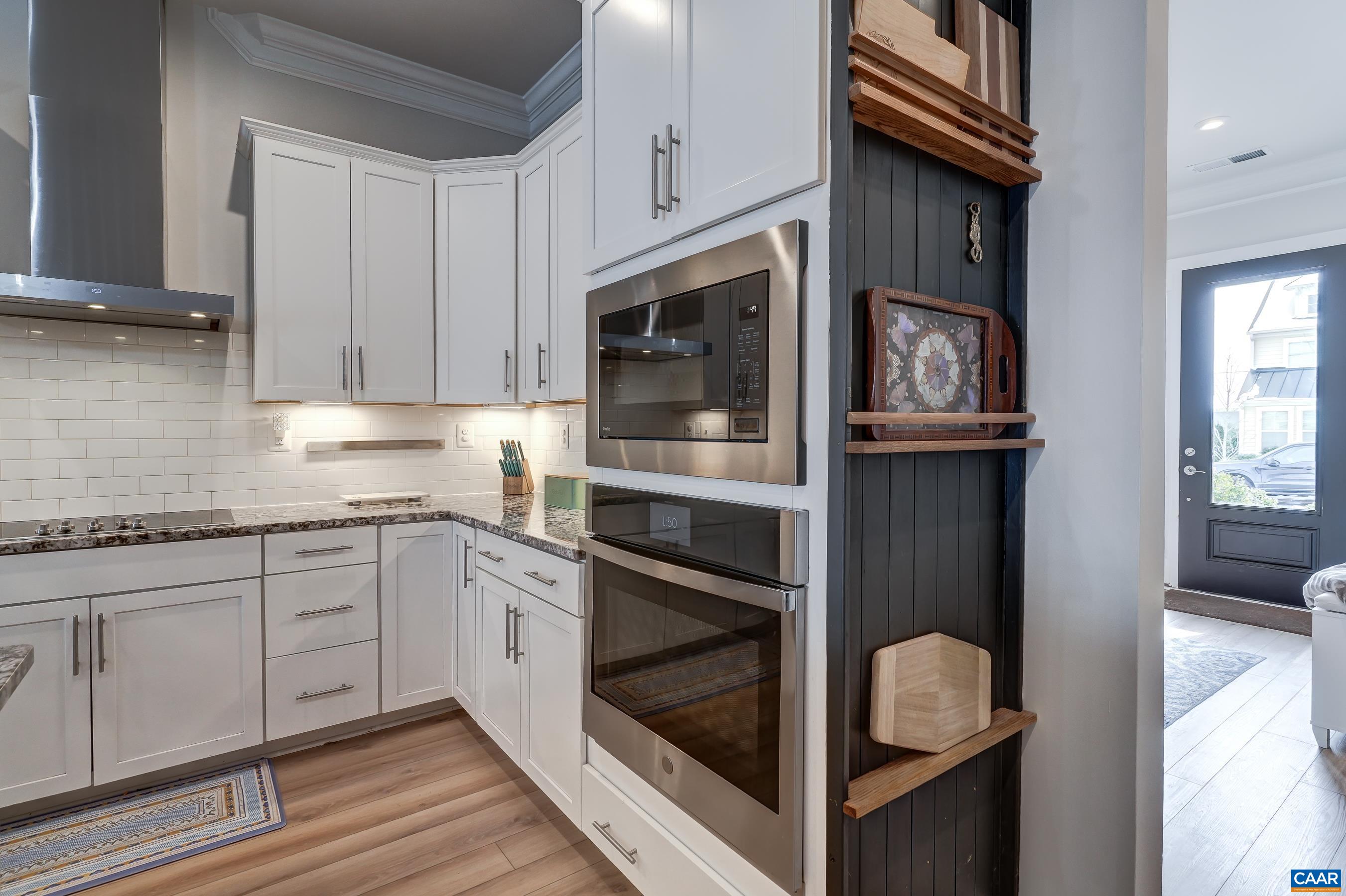 Wall oven and microwave with custom-built storage/display rack.